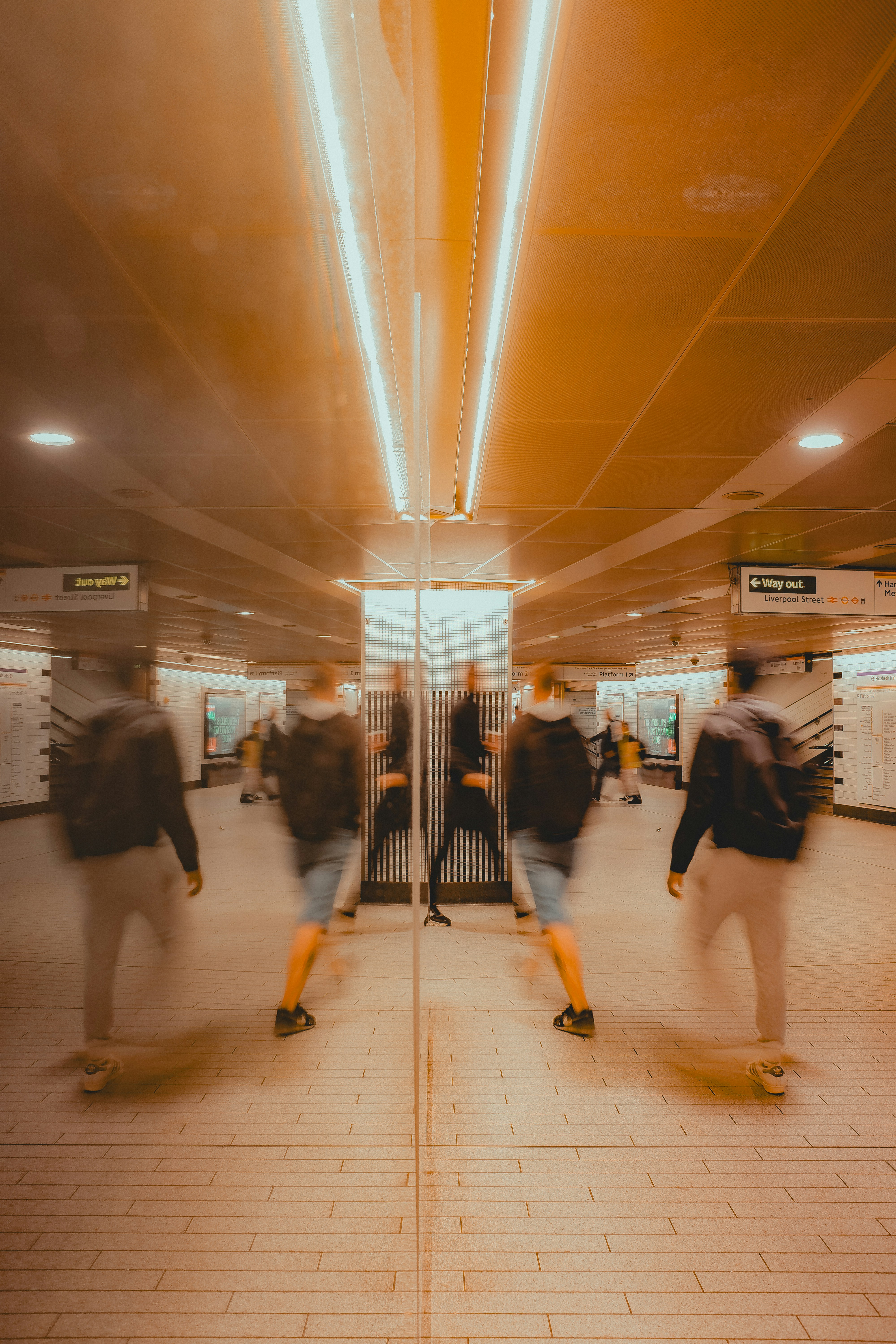 Blurred people walking in a bright subway station.
