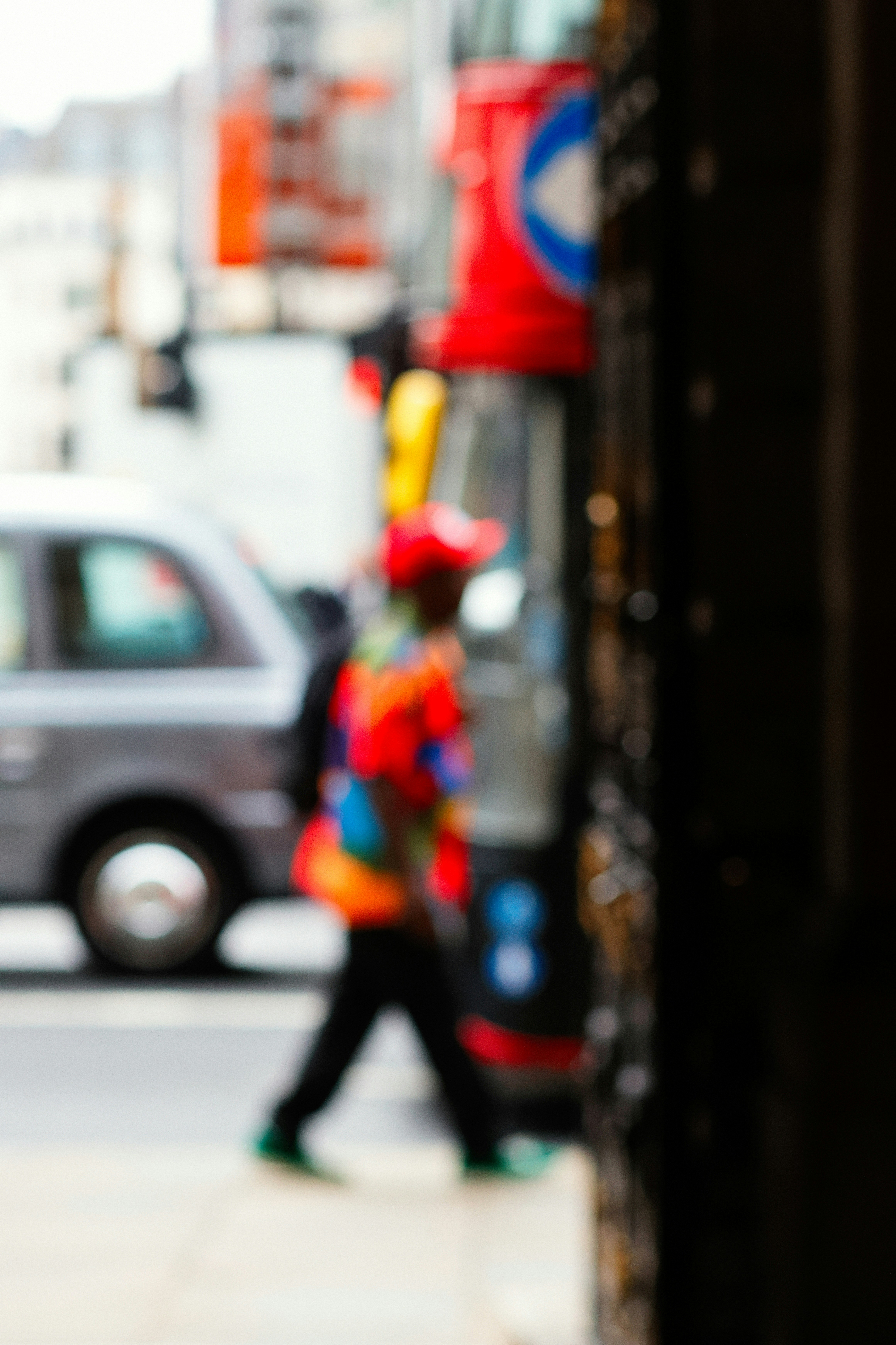 A person walks past a red bus.