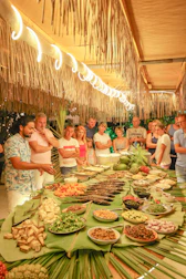 A chef presents food to a crowd at a buffet.