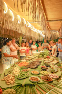 A chef presents food to a crowd at a buffet.