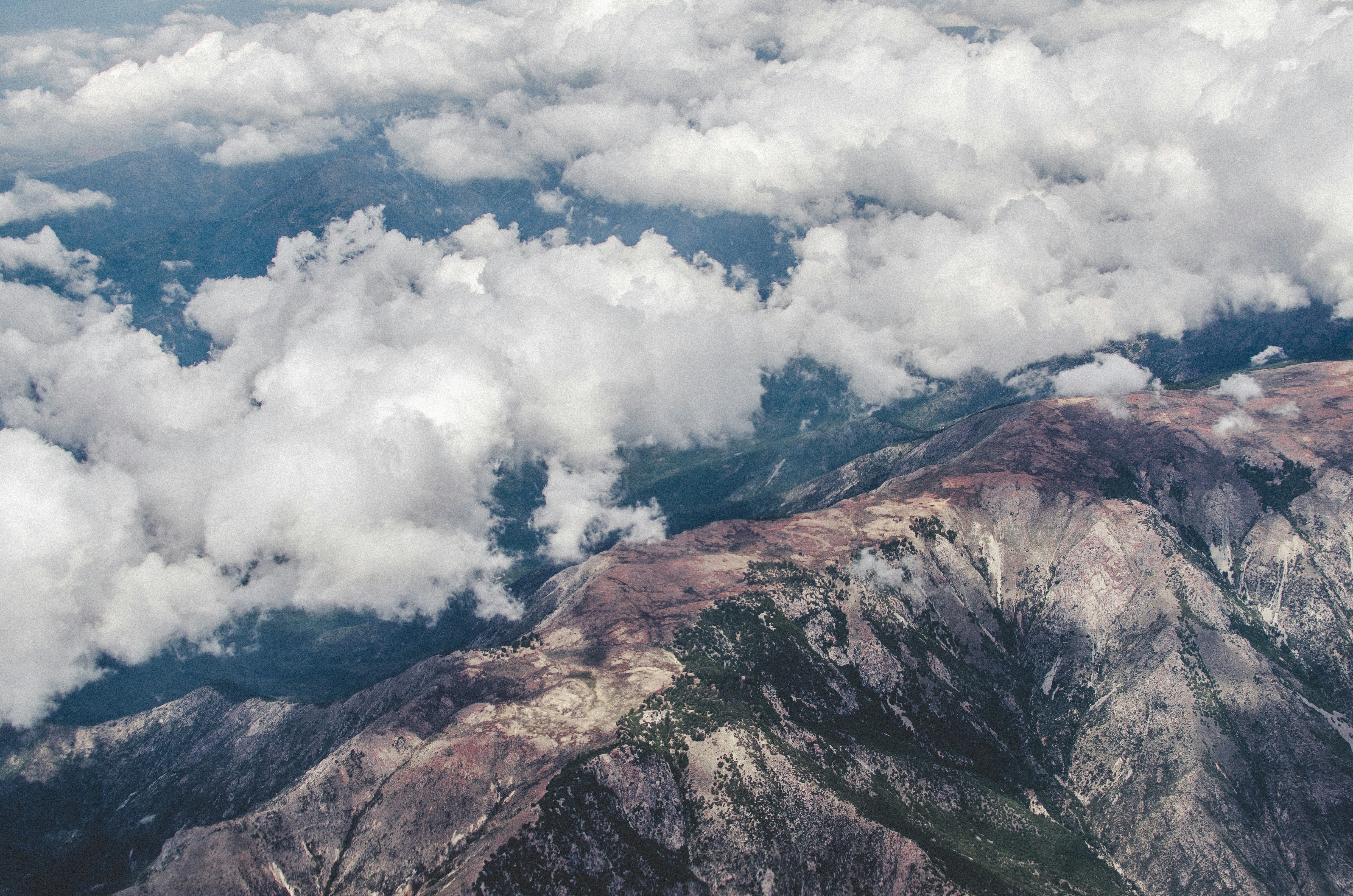 Mountains peeking out from underneath clouds.