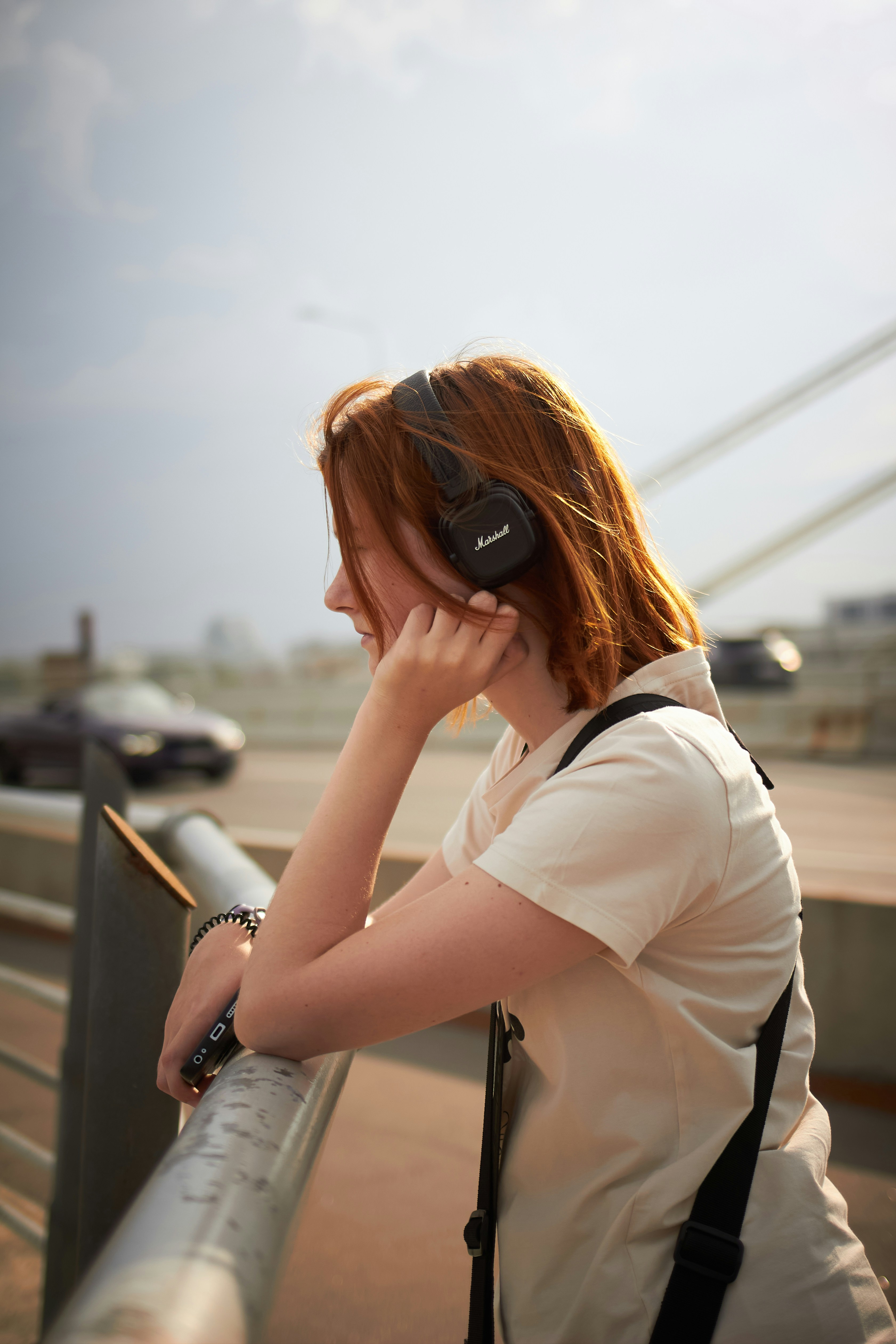 5 Subtle Ways Movie Soundtracks Manipulate Your Emotions – Young woman listening to music outdoors with headphones.