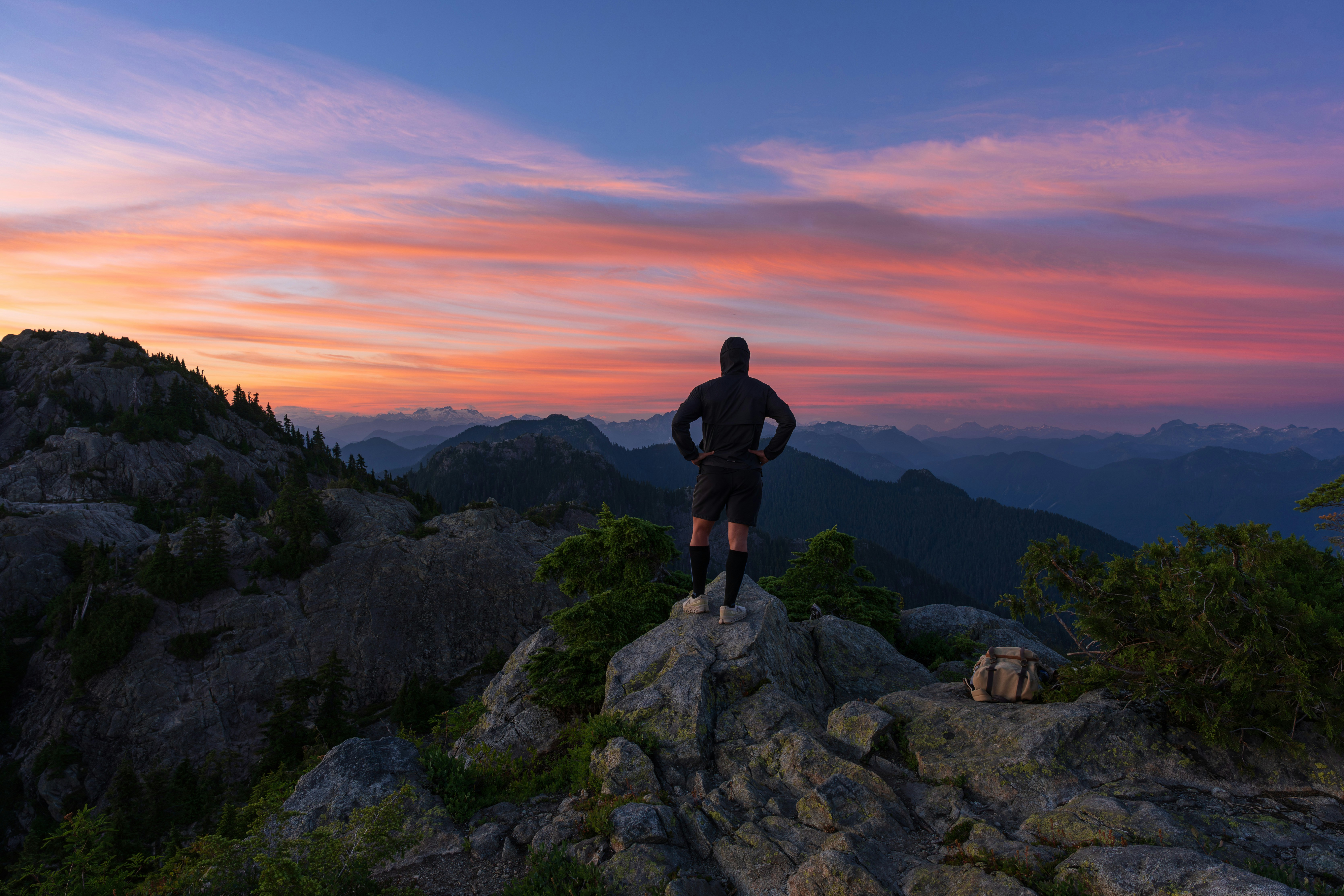 A hiker enjoys a beautiful sunset from a mountain.
