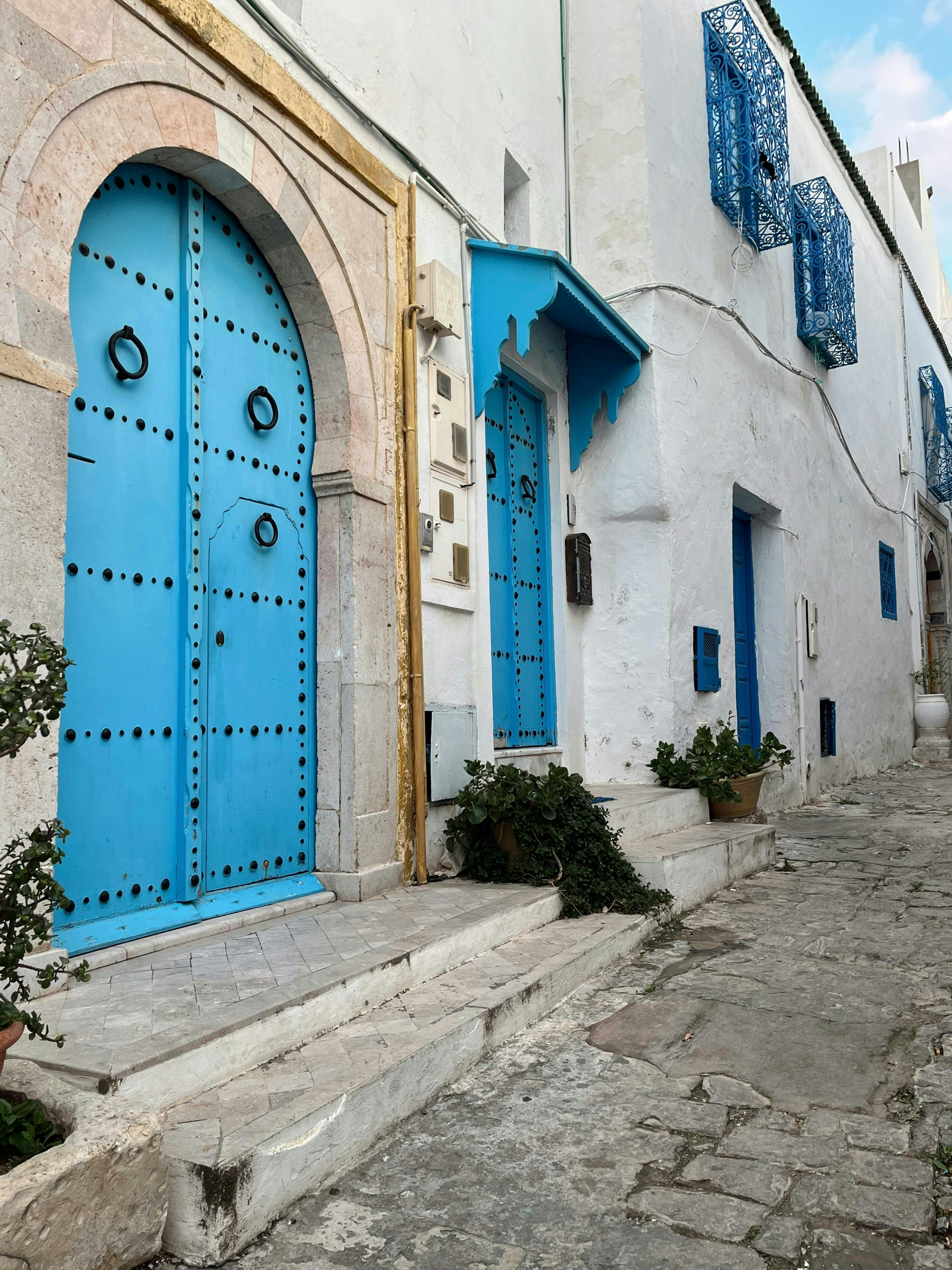 Vibrant blue doors adorn a charming white building.