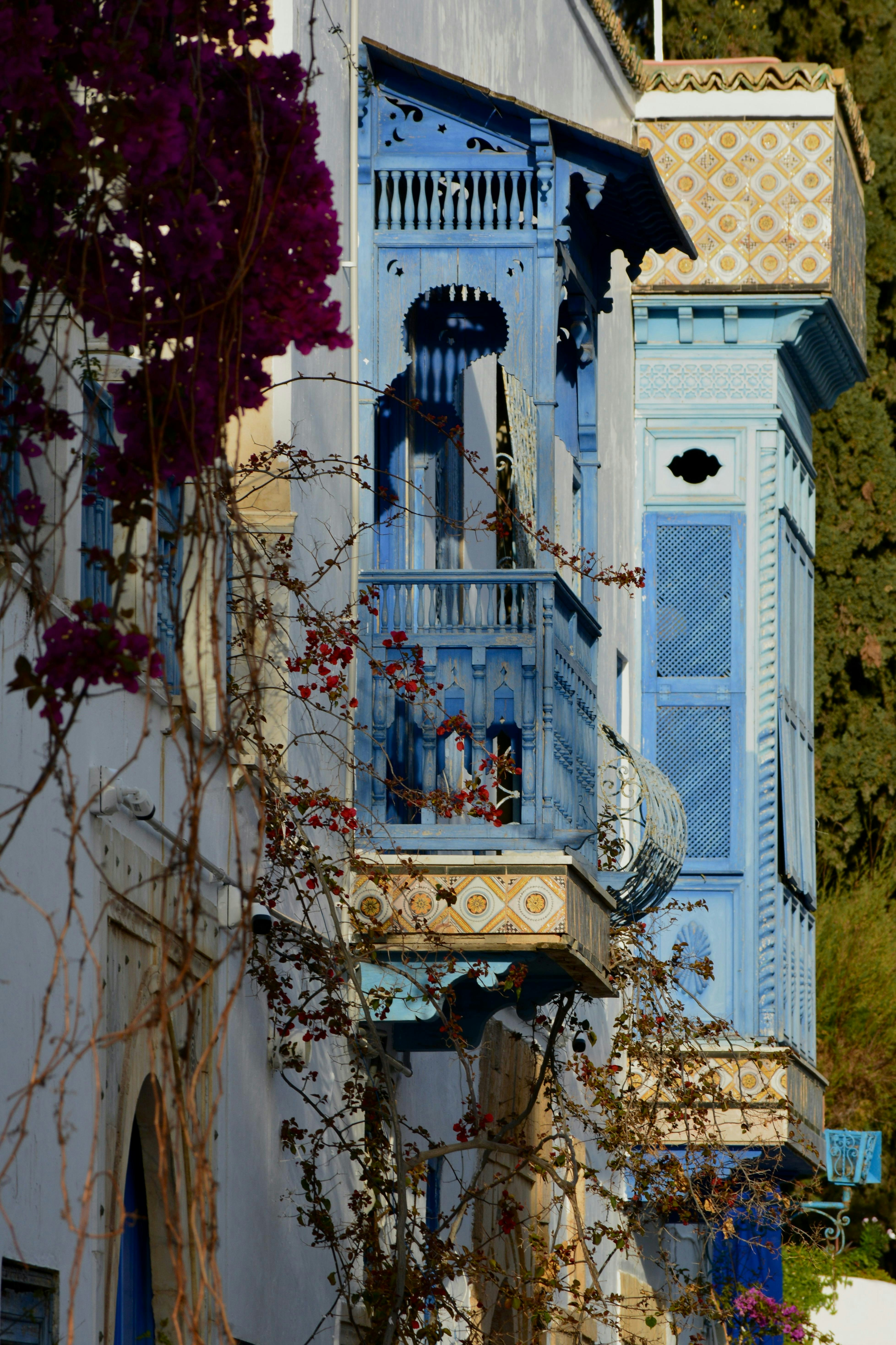 Blue balcony adorned with vibrant, colorful flowers.