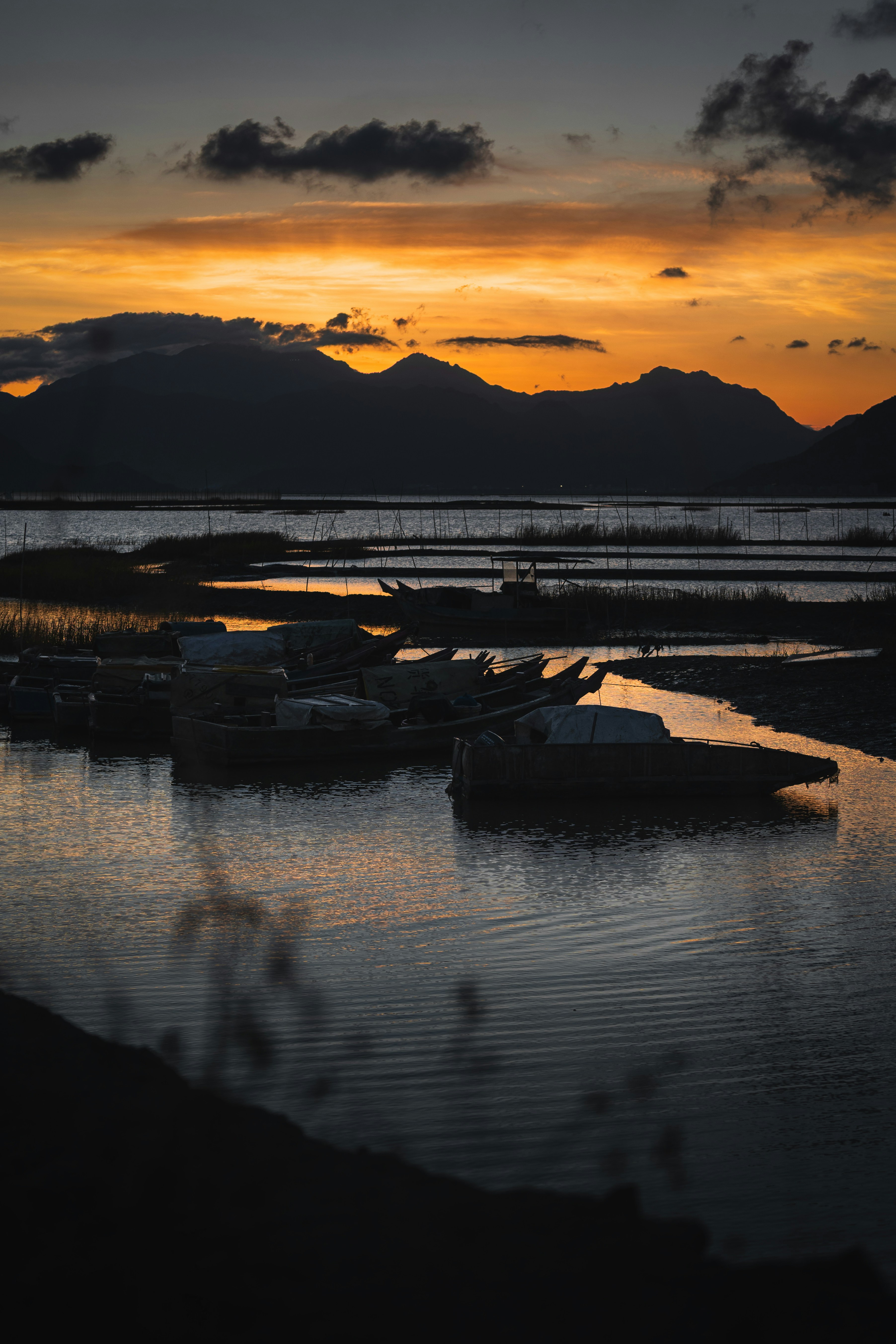 Os barcos sentam-se na água ao pôr do sol.
