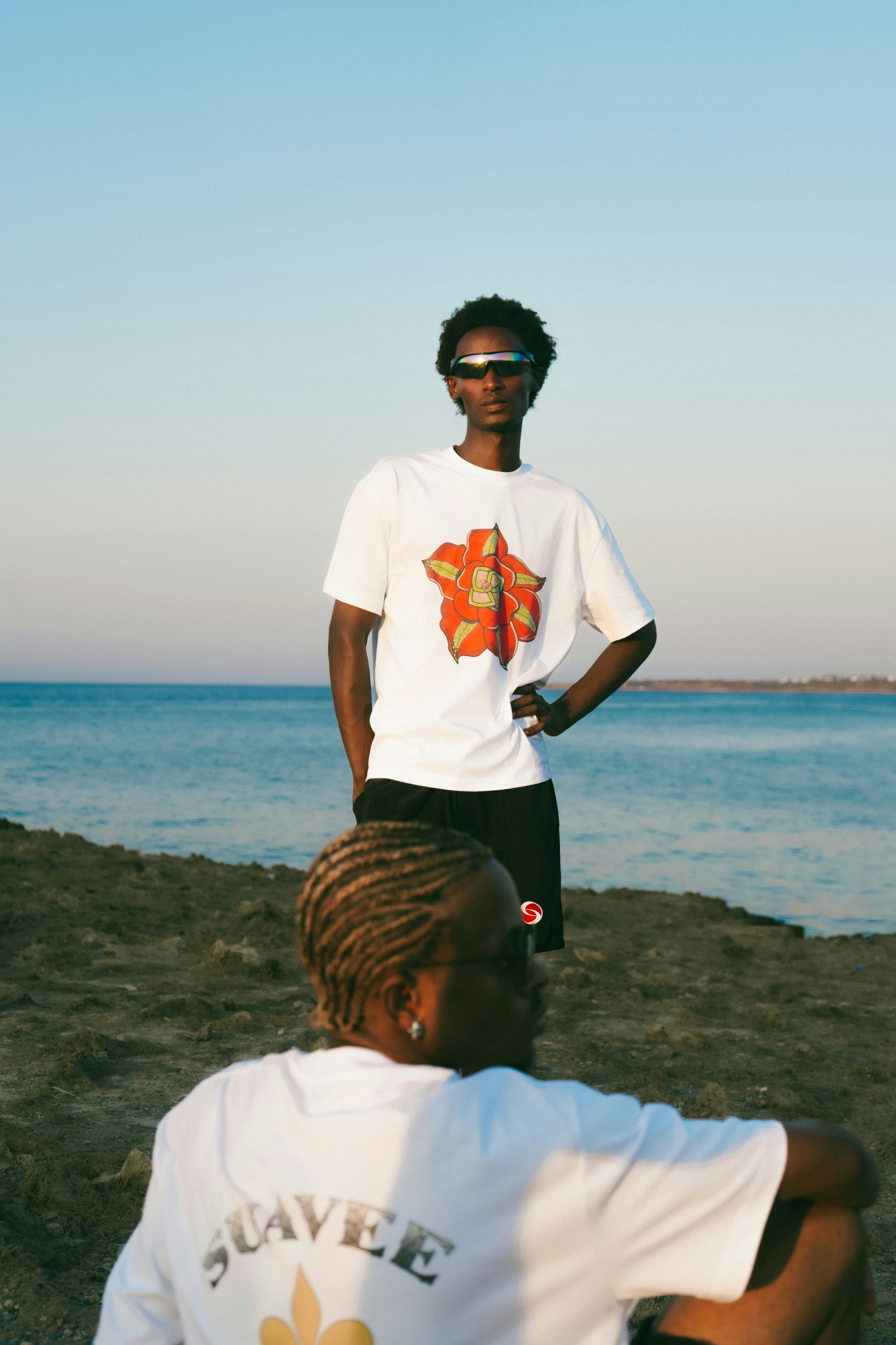Two people by the ocean at sunset