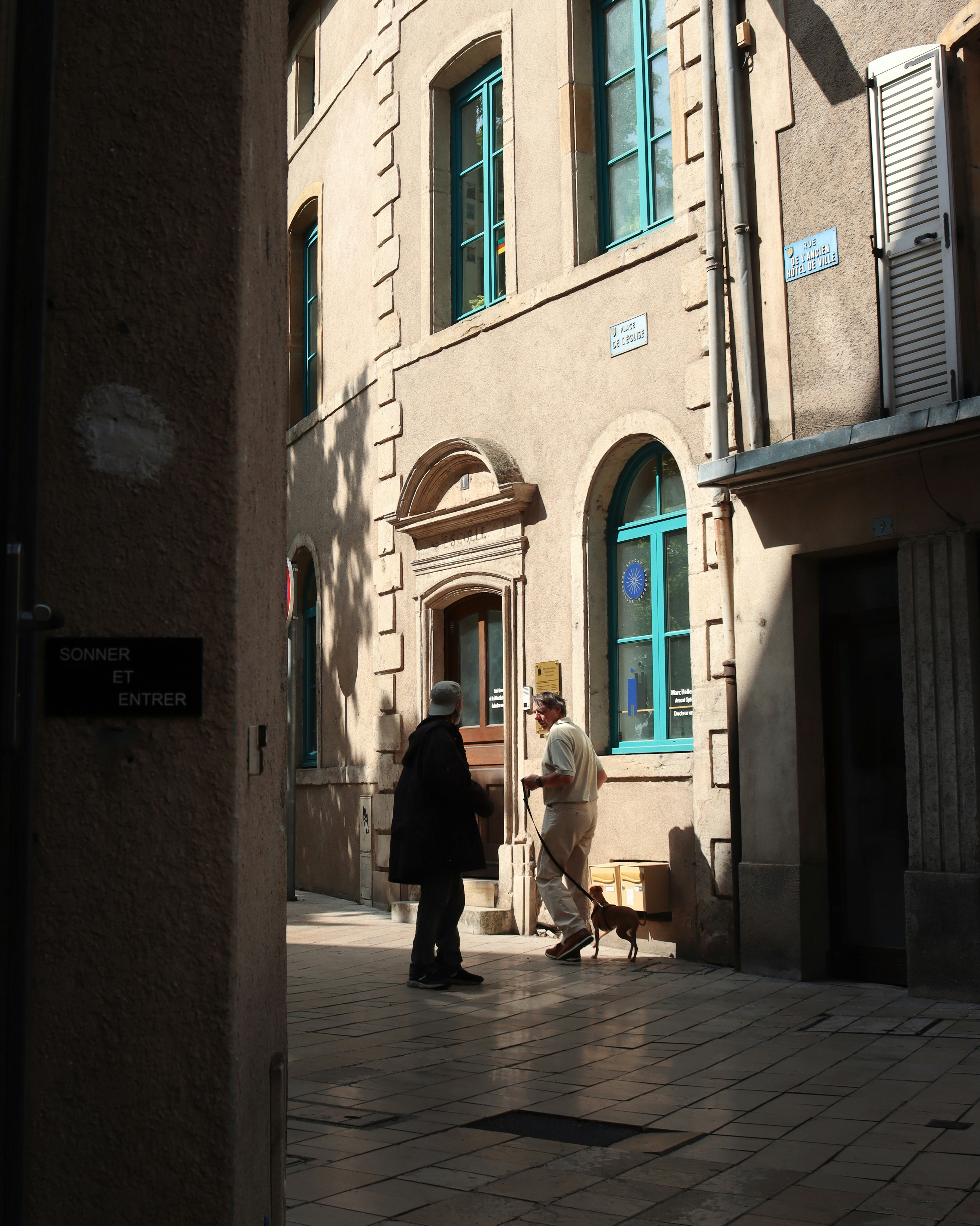 Two people converse outside a building.