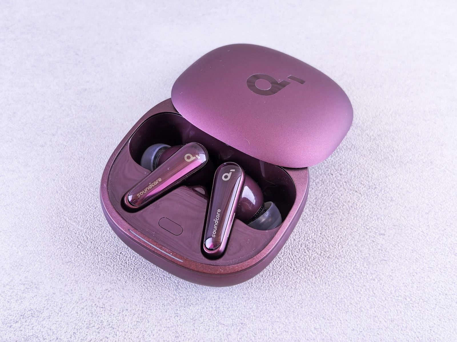 Wireless earbuds resting inside their charging case