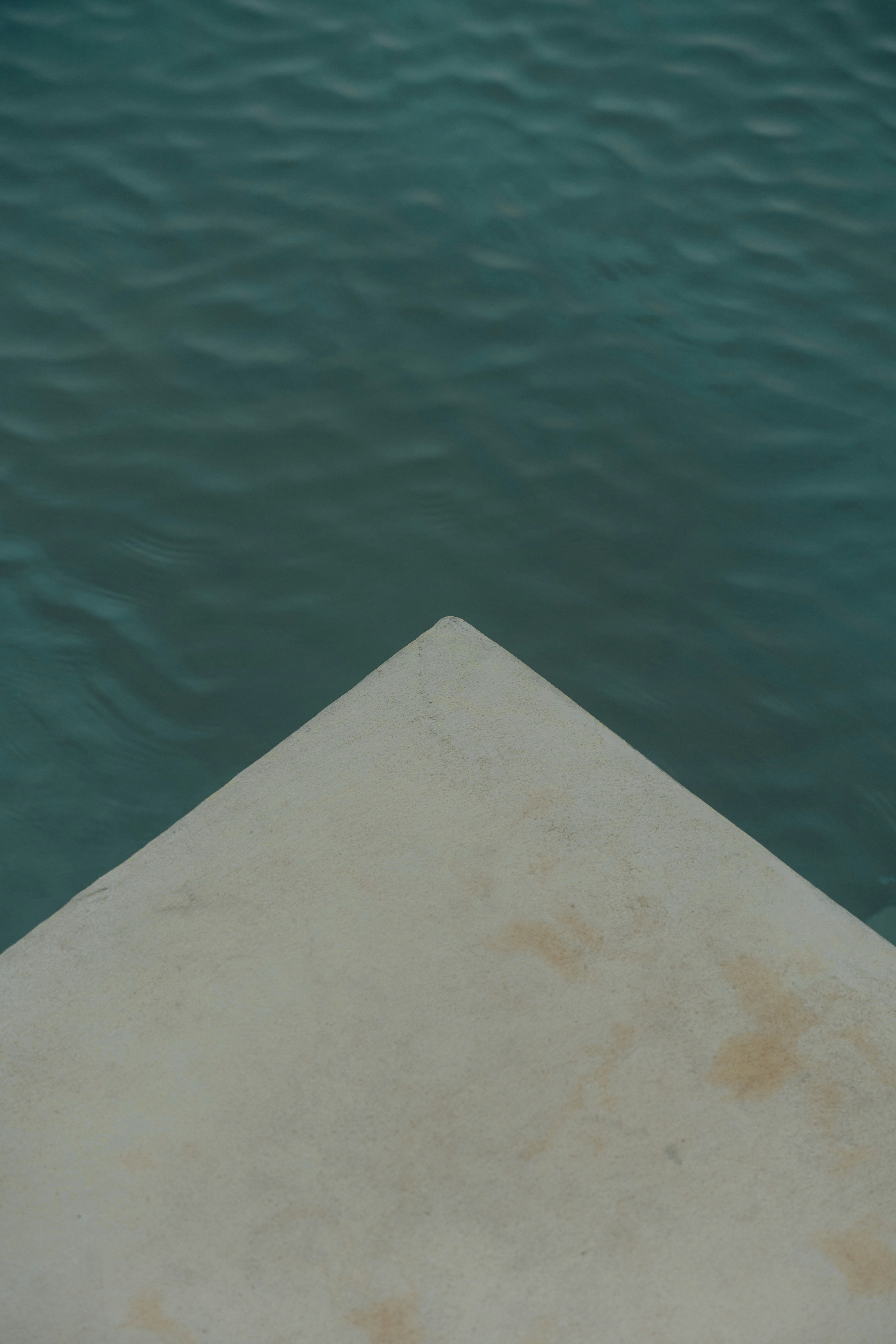 Un angolo di pietra si affaccia sull'acqua calma.