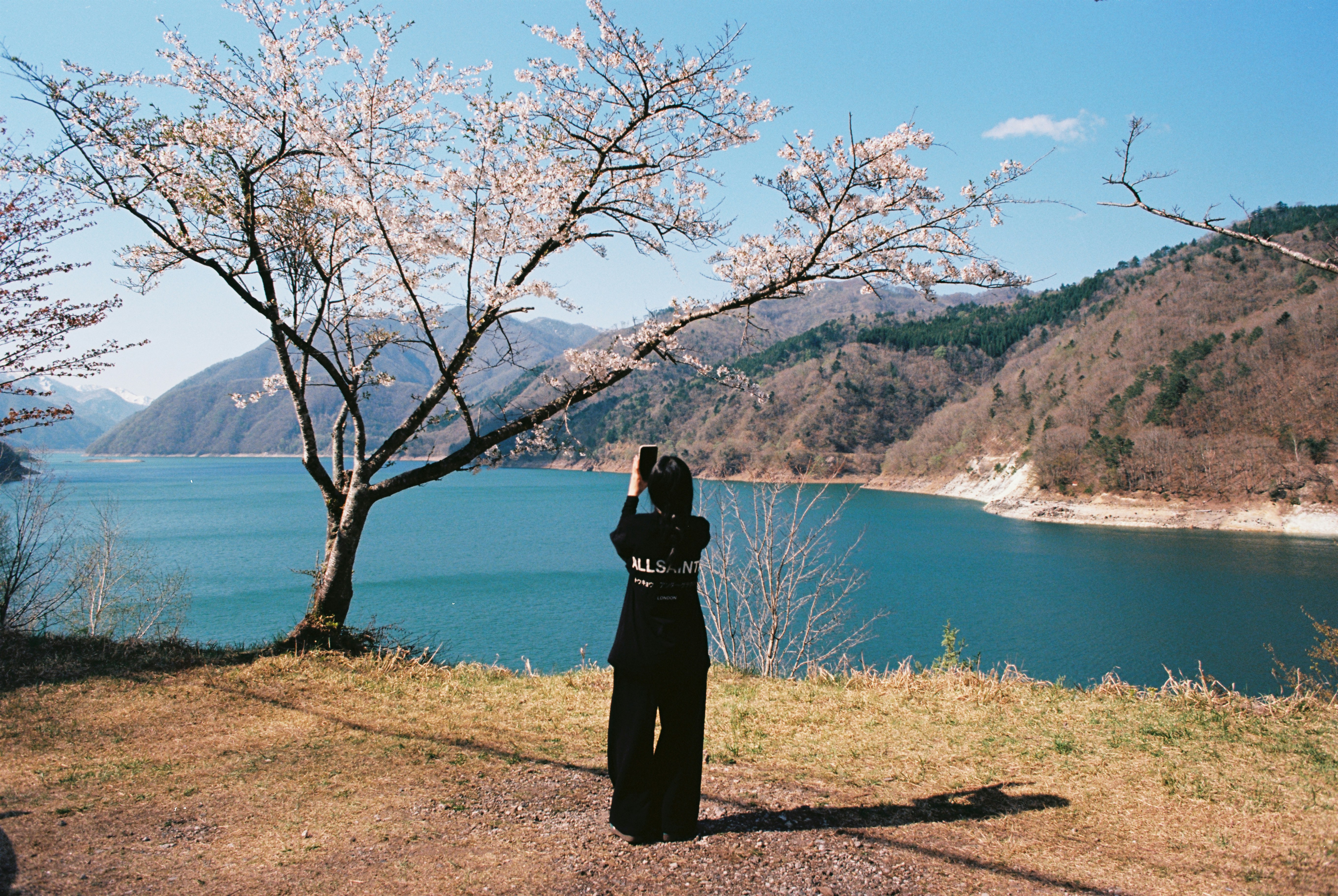 Person photographs a beautiful lake with mountains.