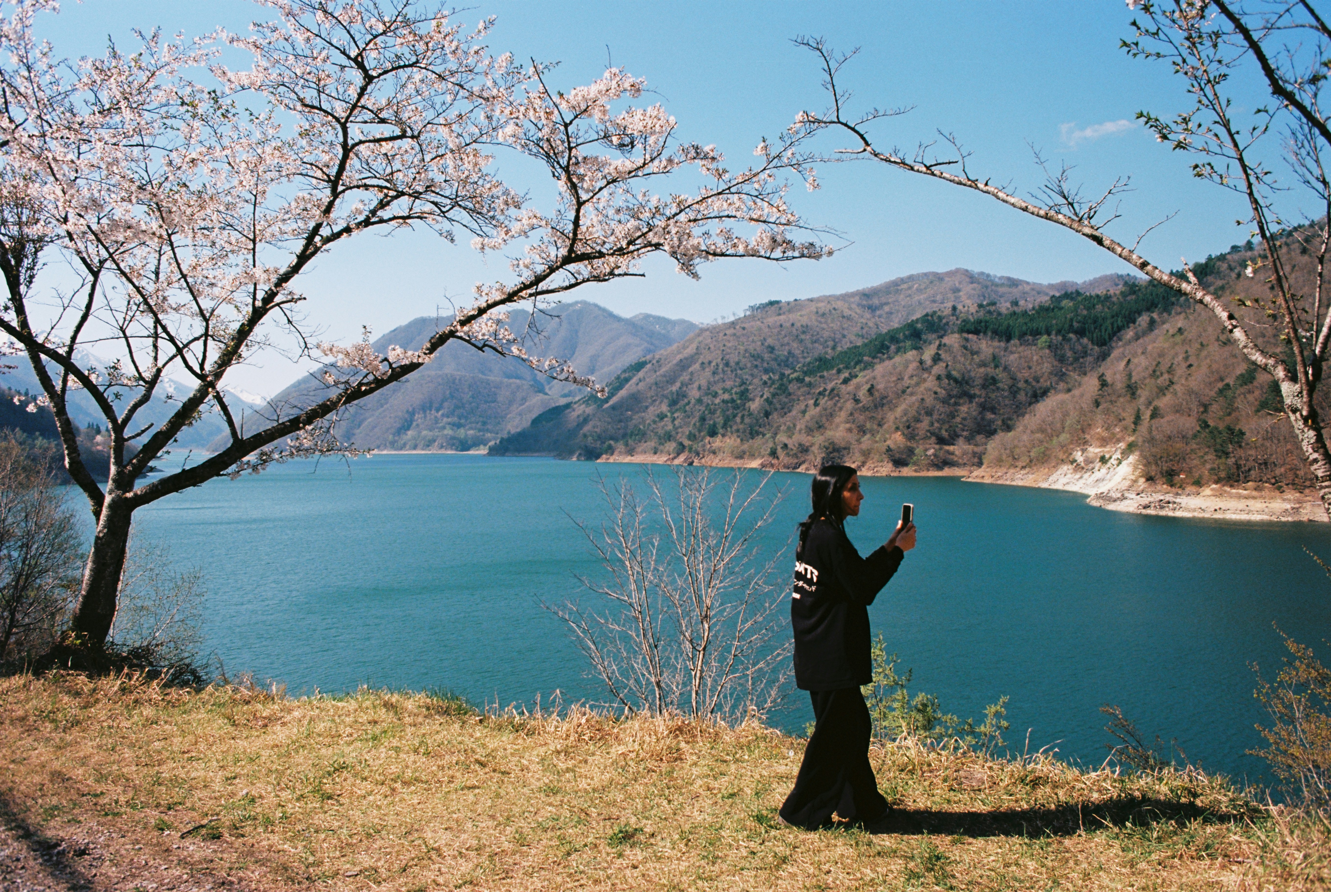 Person taking a photo of a beautiful lake view.