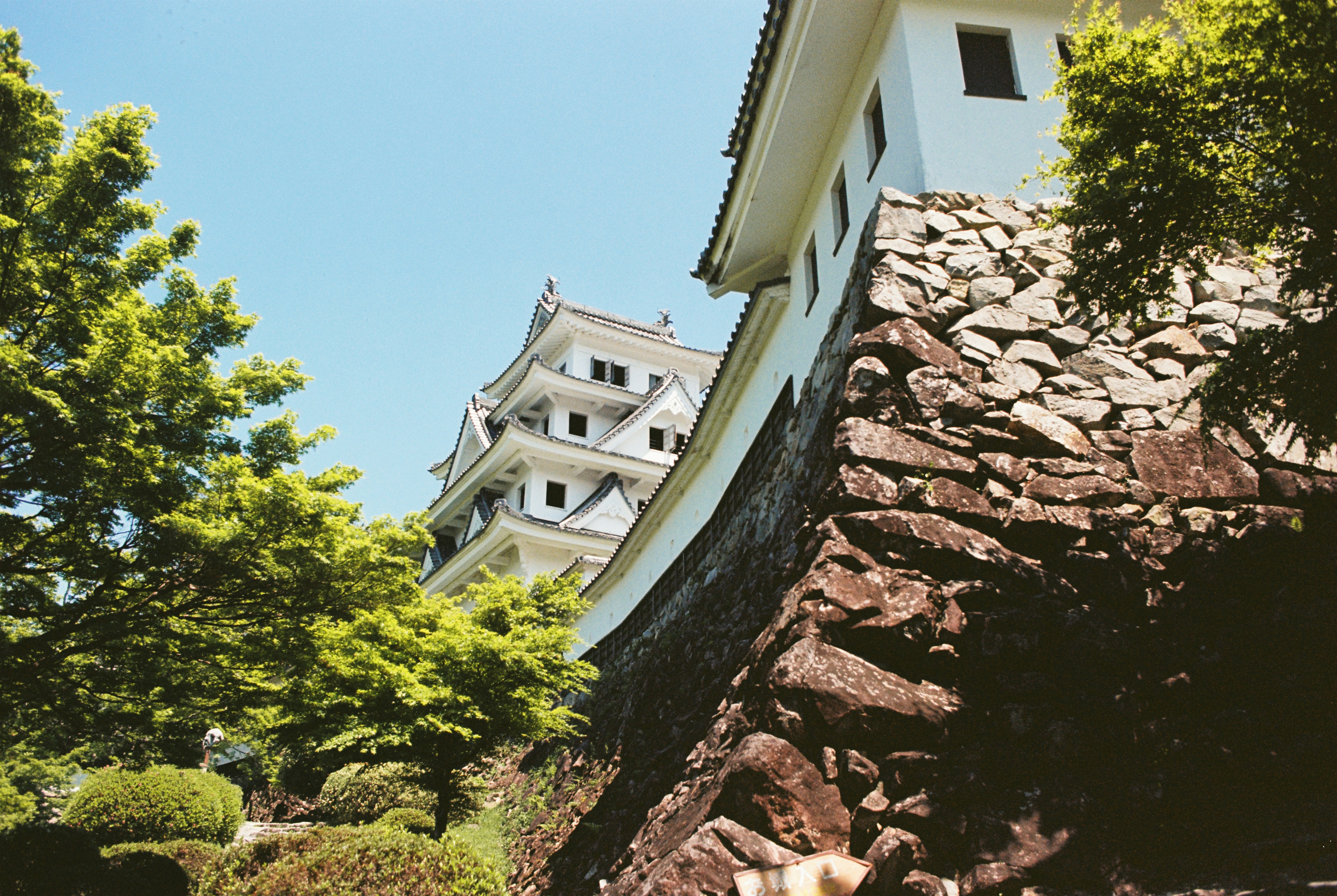 A japanese castle stands tall in the sunlight.