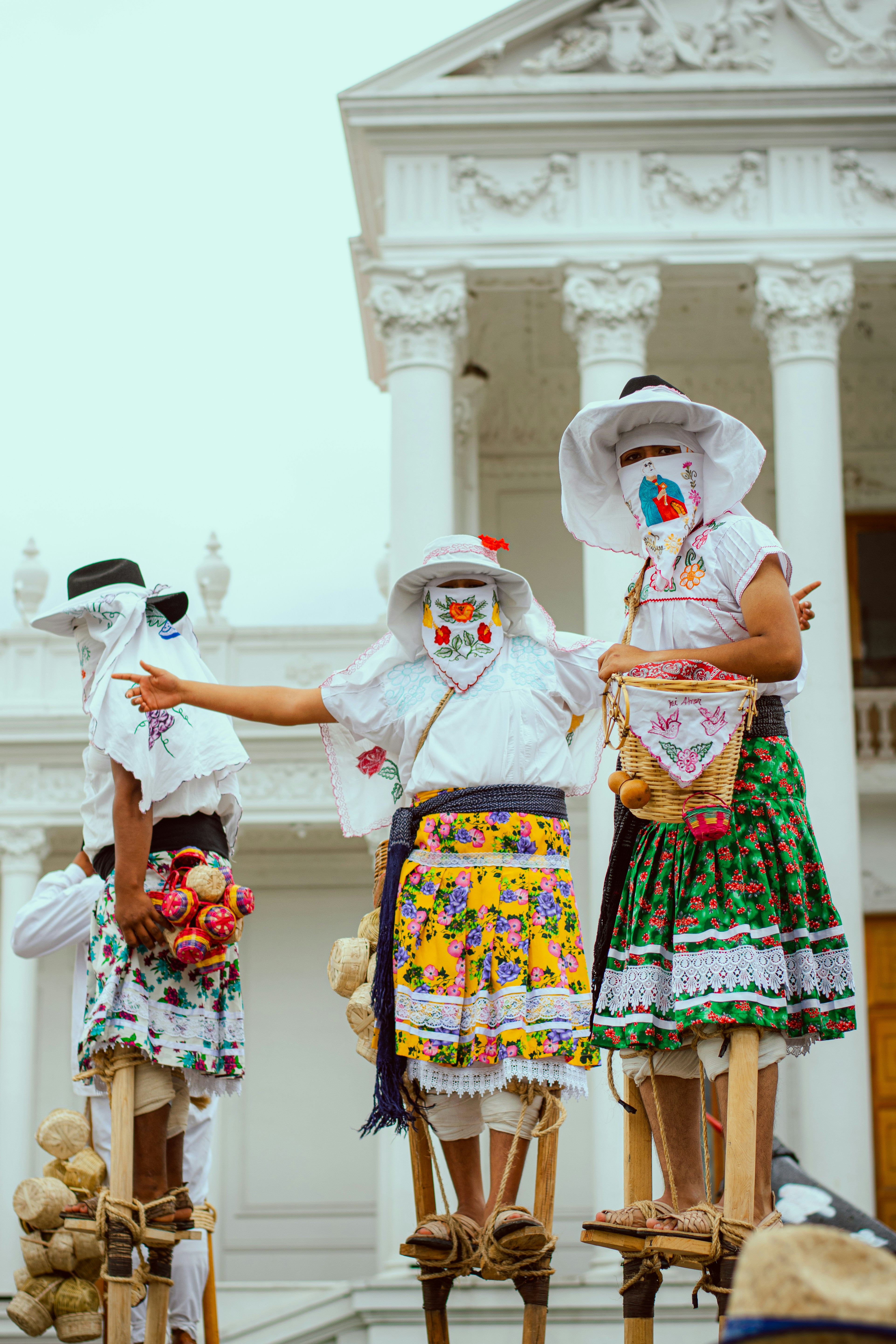 People in traditional costumes perform on stilts.