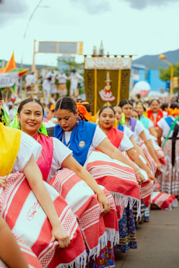 Women in colorful traditional clothing dancing in a parade
