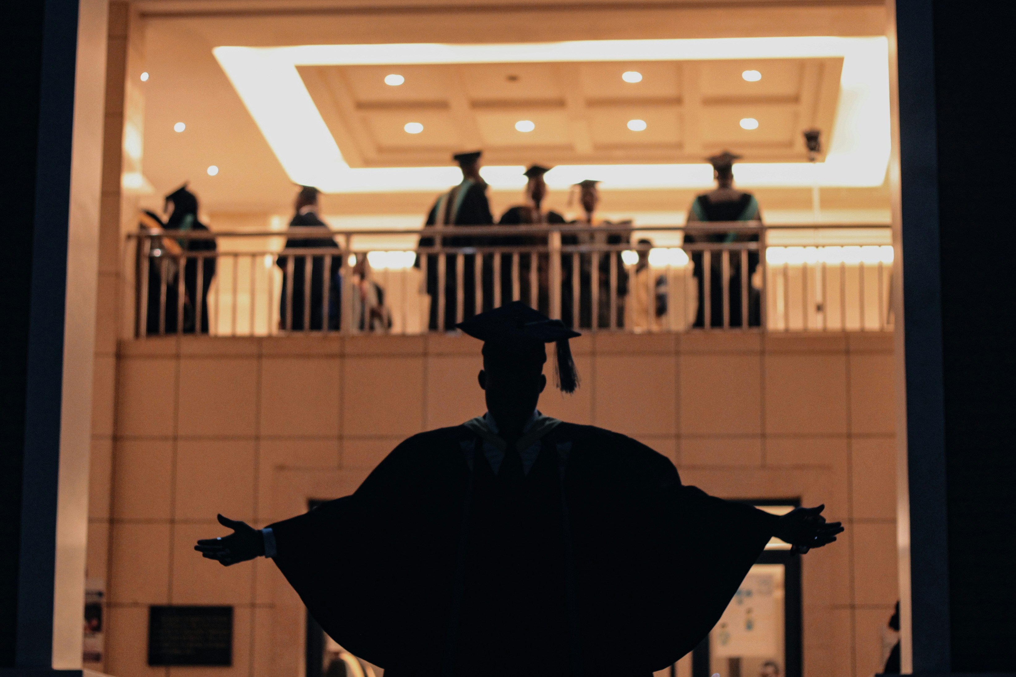 Graduates celebrate on a balcony during a ceremony.
