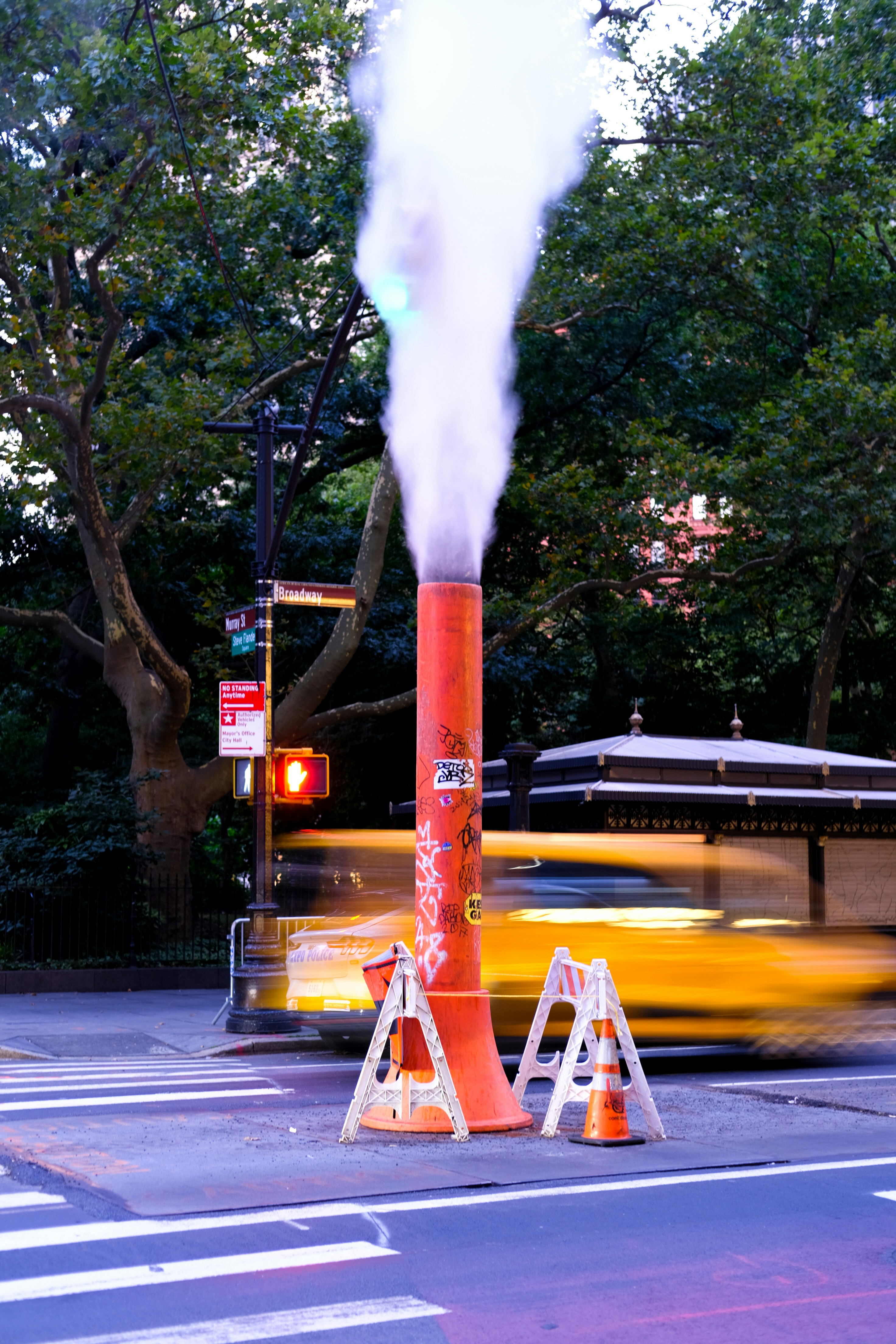 Steam escapes from a street vent in the city.