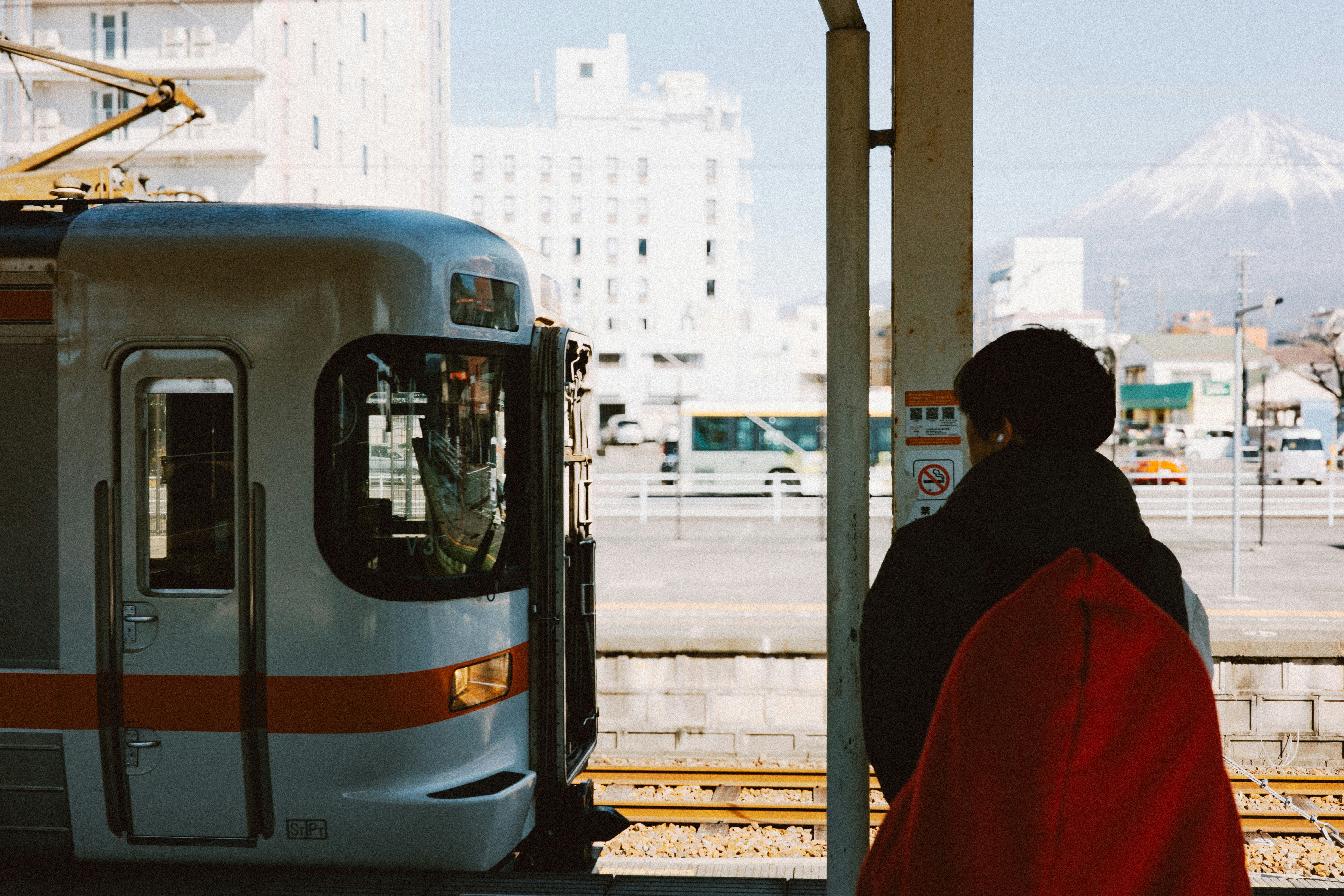 Eine Person wartet am Bahnhof auf einen Zug.