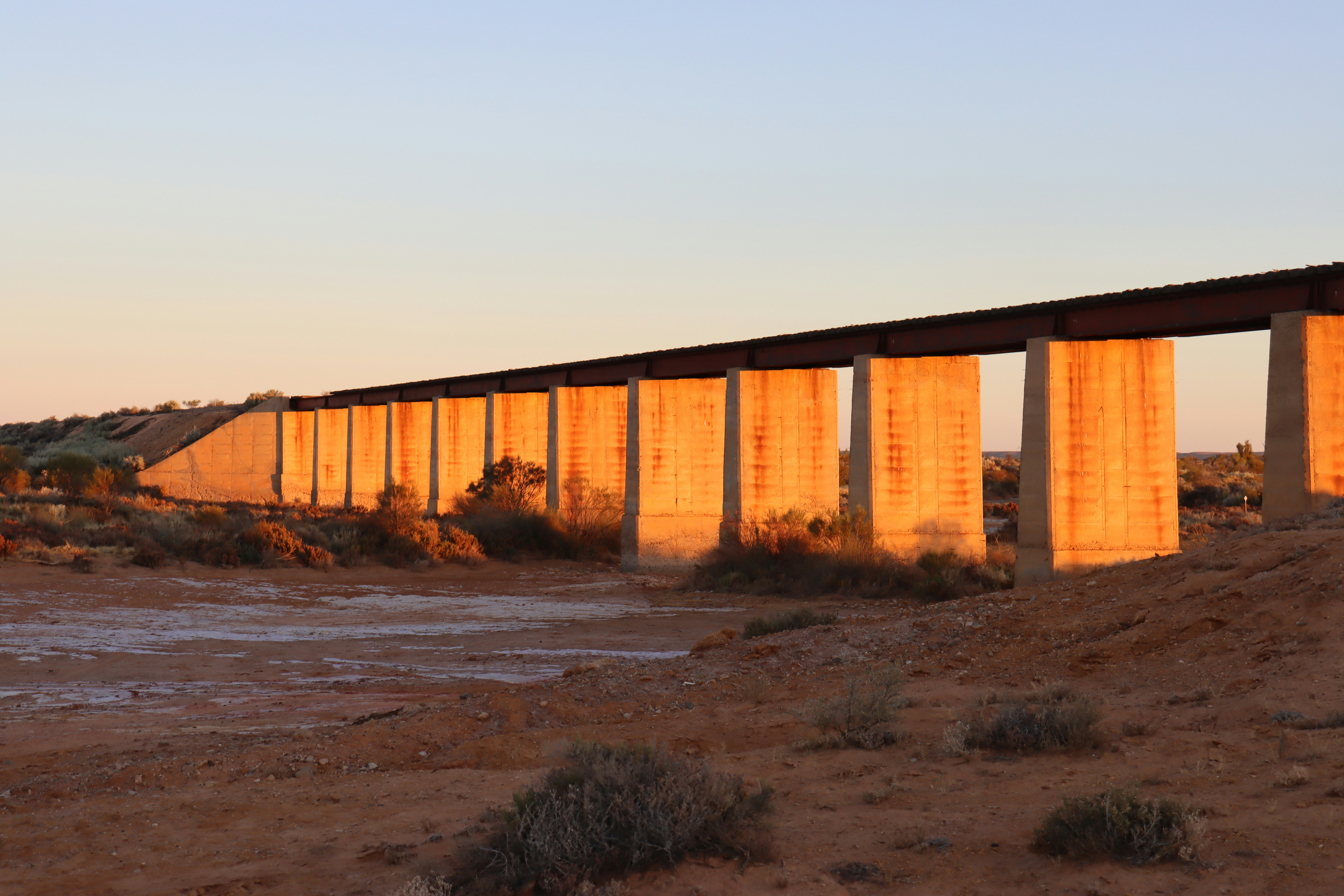 A long bridge spans a desert landscape.
