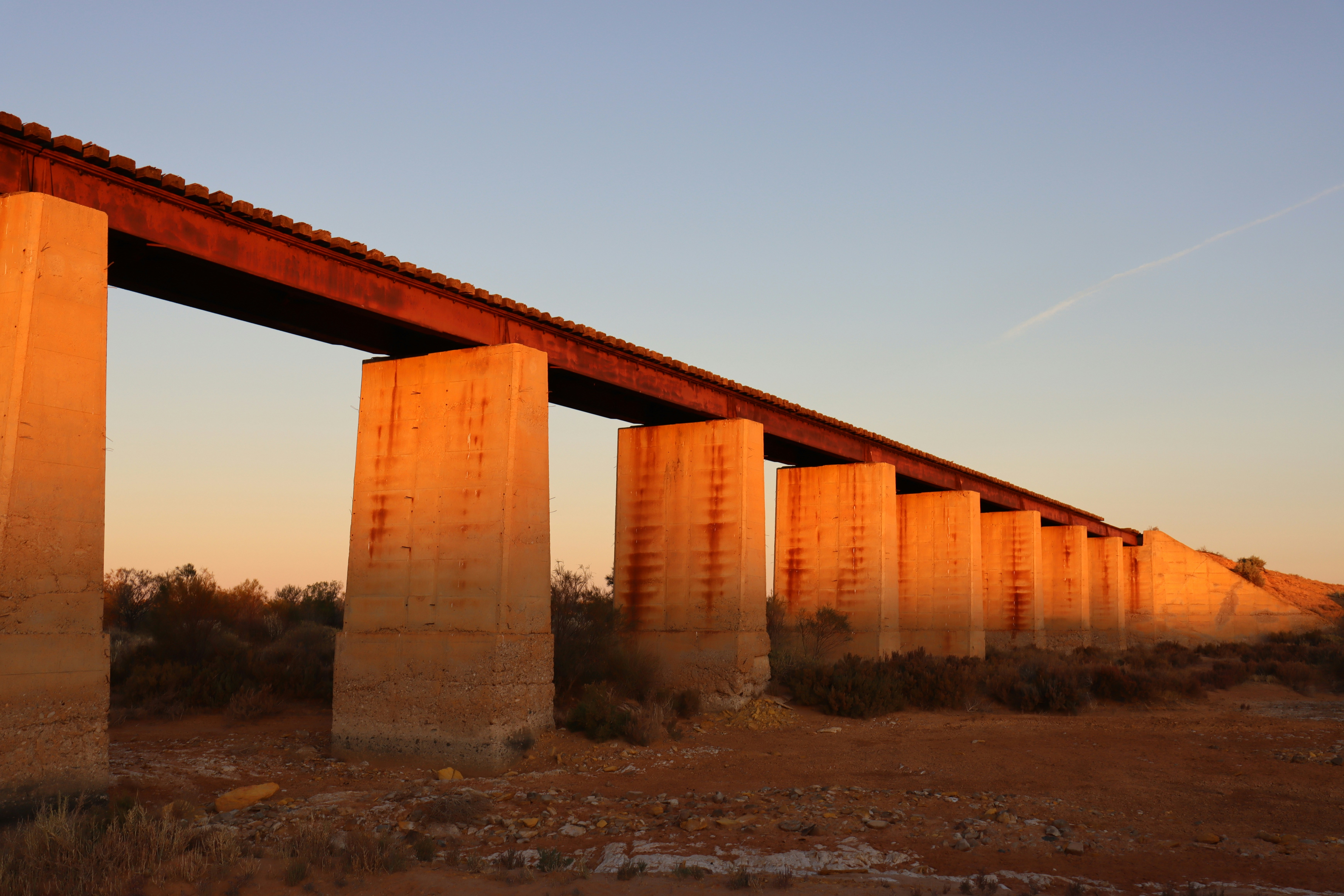 Sunlight bathes the bridge's support pillars.