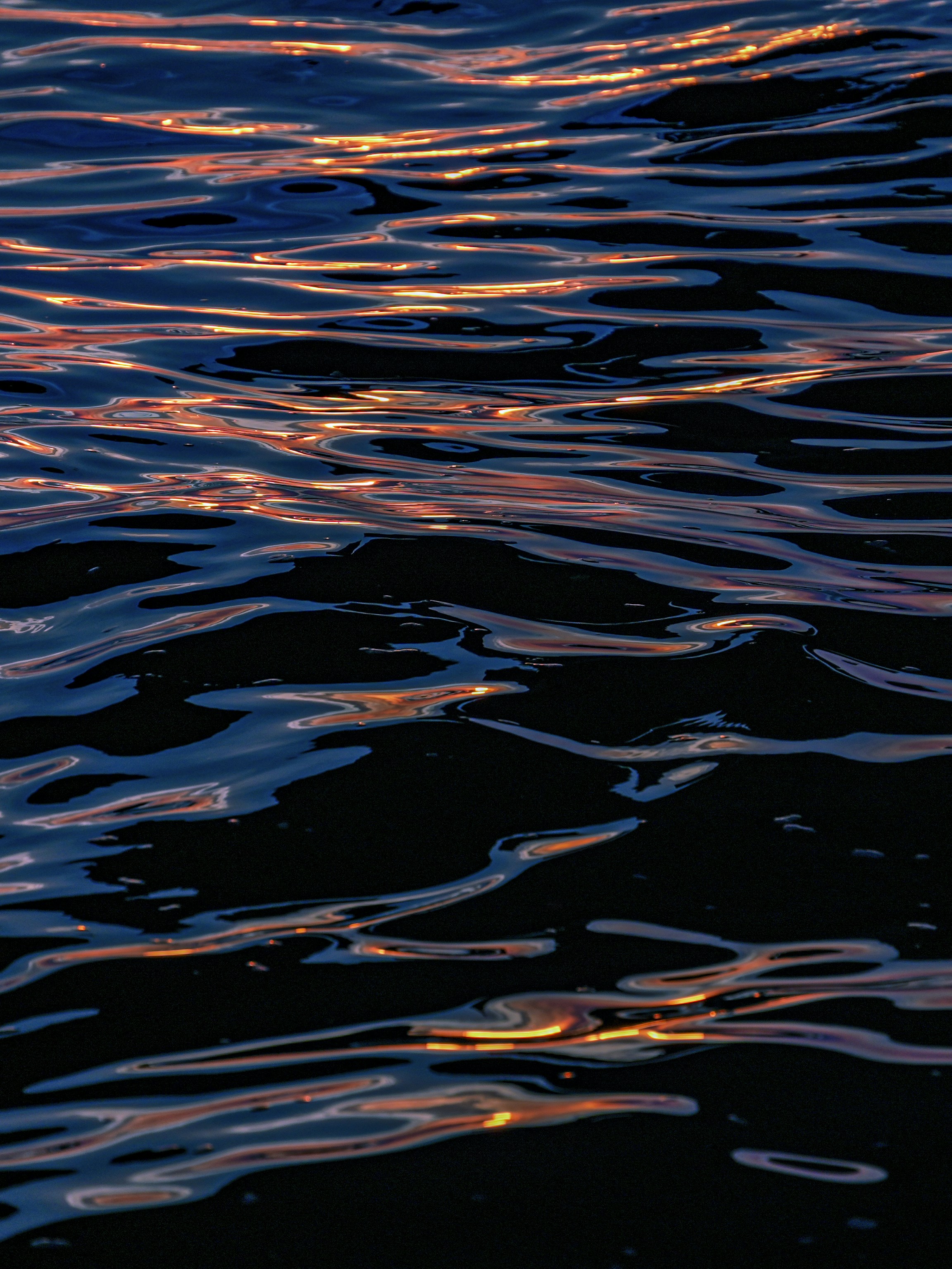 Reflections of light shimmer on dark water.