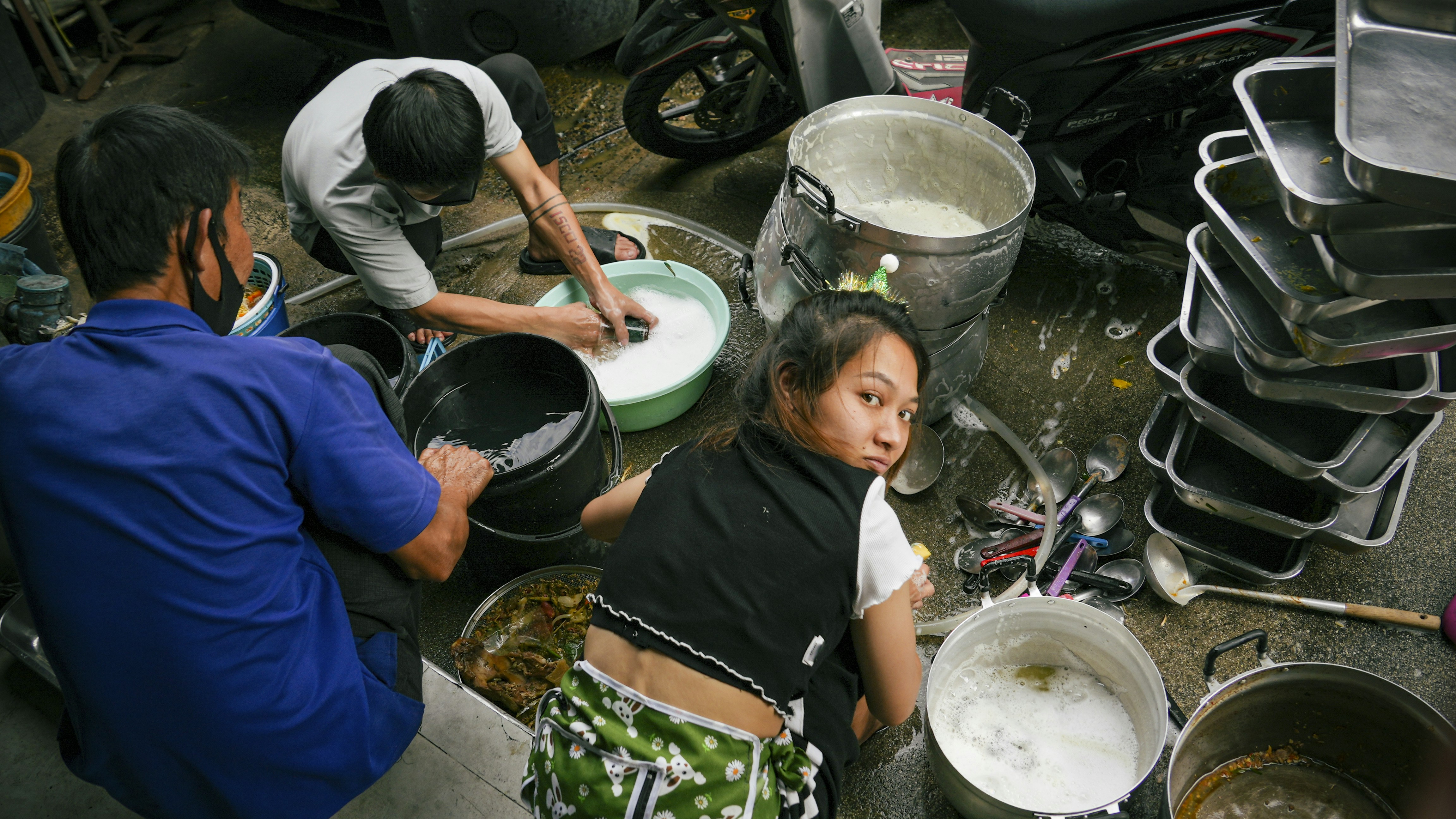 Menschen spülen Geschirr auf dem Boden.