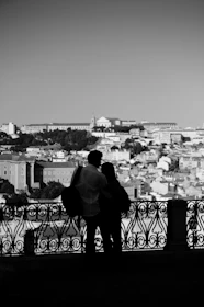 A couple silhouetted, viewing a cityscape.