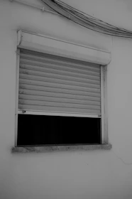 A window with a partially closed shutter.