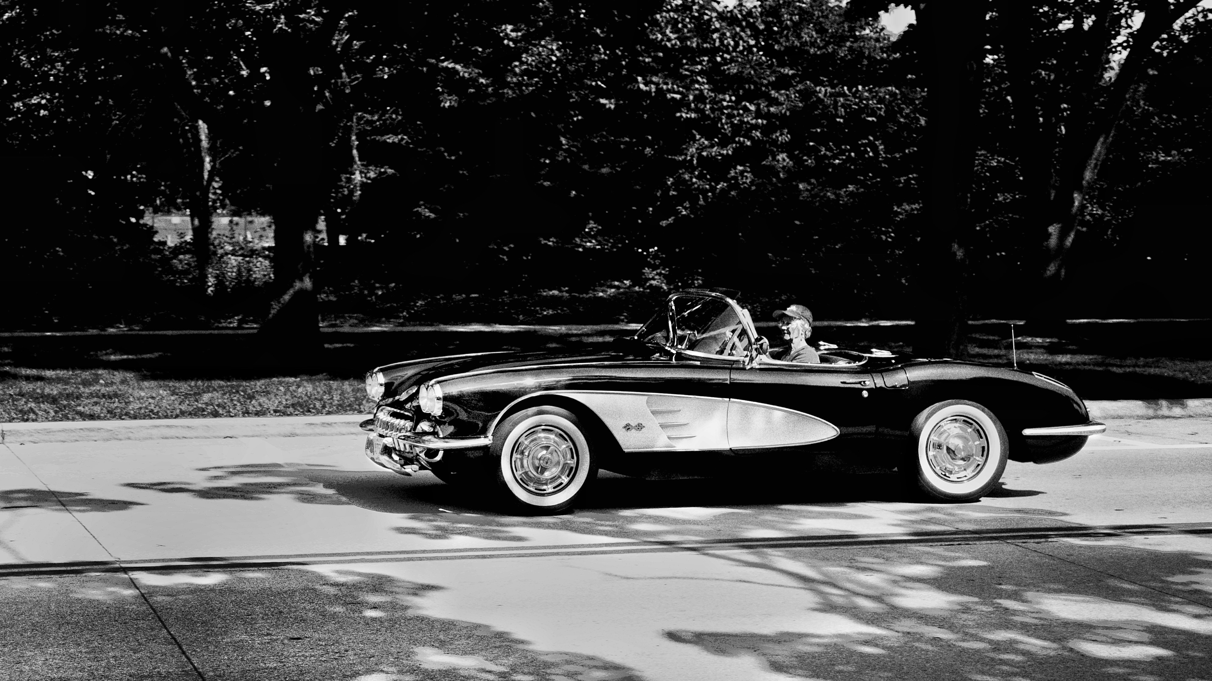 클래식 컨버터블 자동차가 도로를 달리고 있습니다.