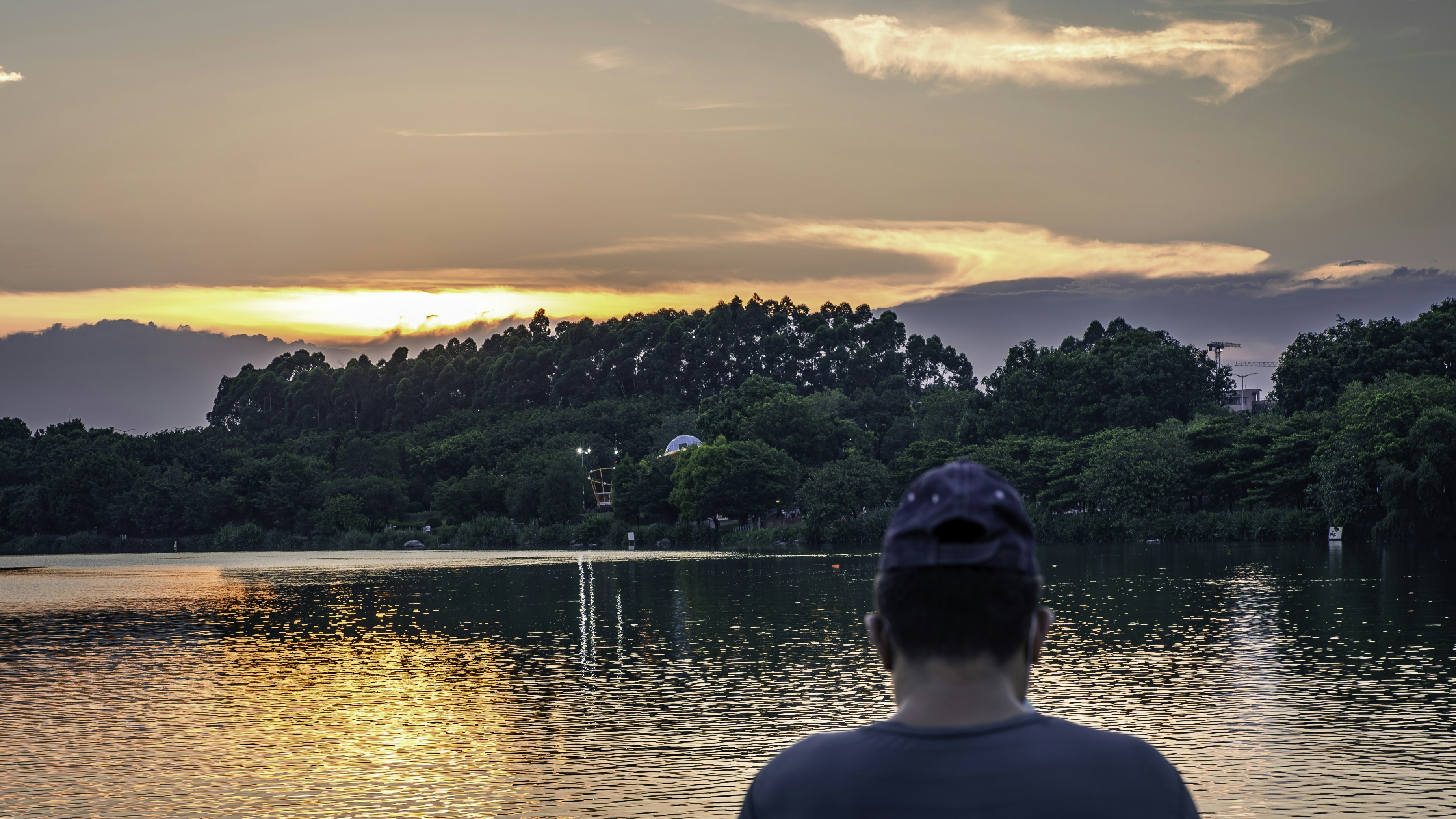 Persona contemplando lago al atardecer