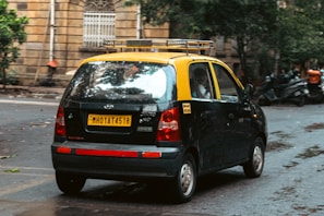 A yellow-top taxi waits on a city street.