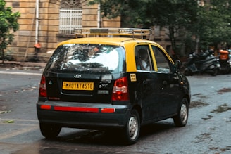 A yellow-top taxi waits on a city street.