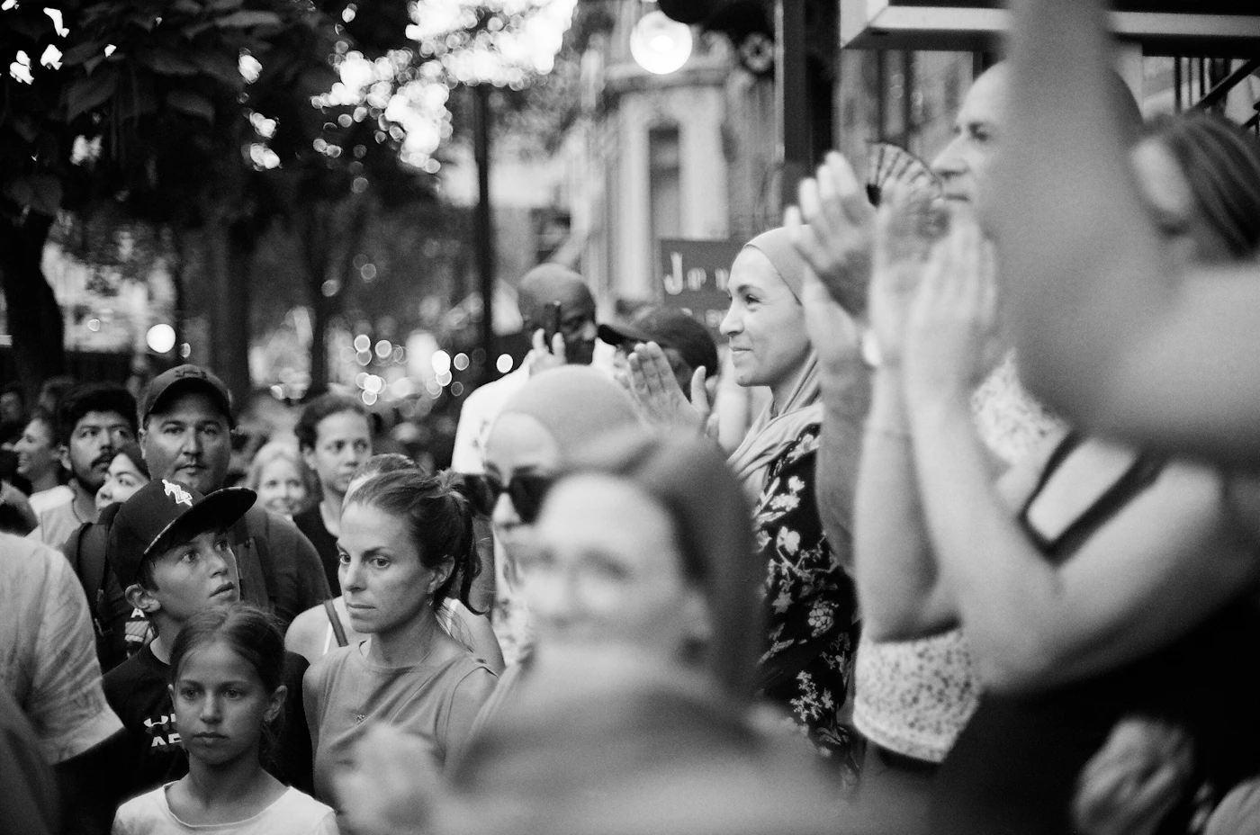Crowd of people at an event clapping and watching something showing the guests at a celebration that a wedding photographer documents throughout the full day