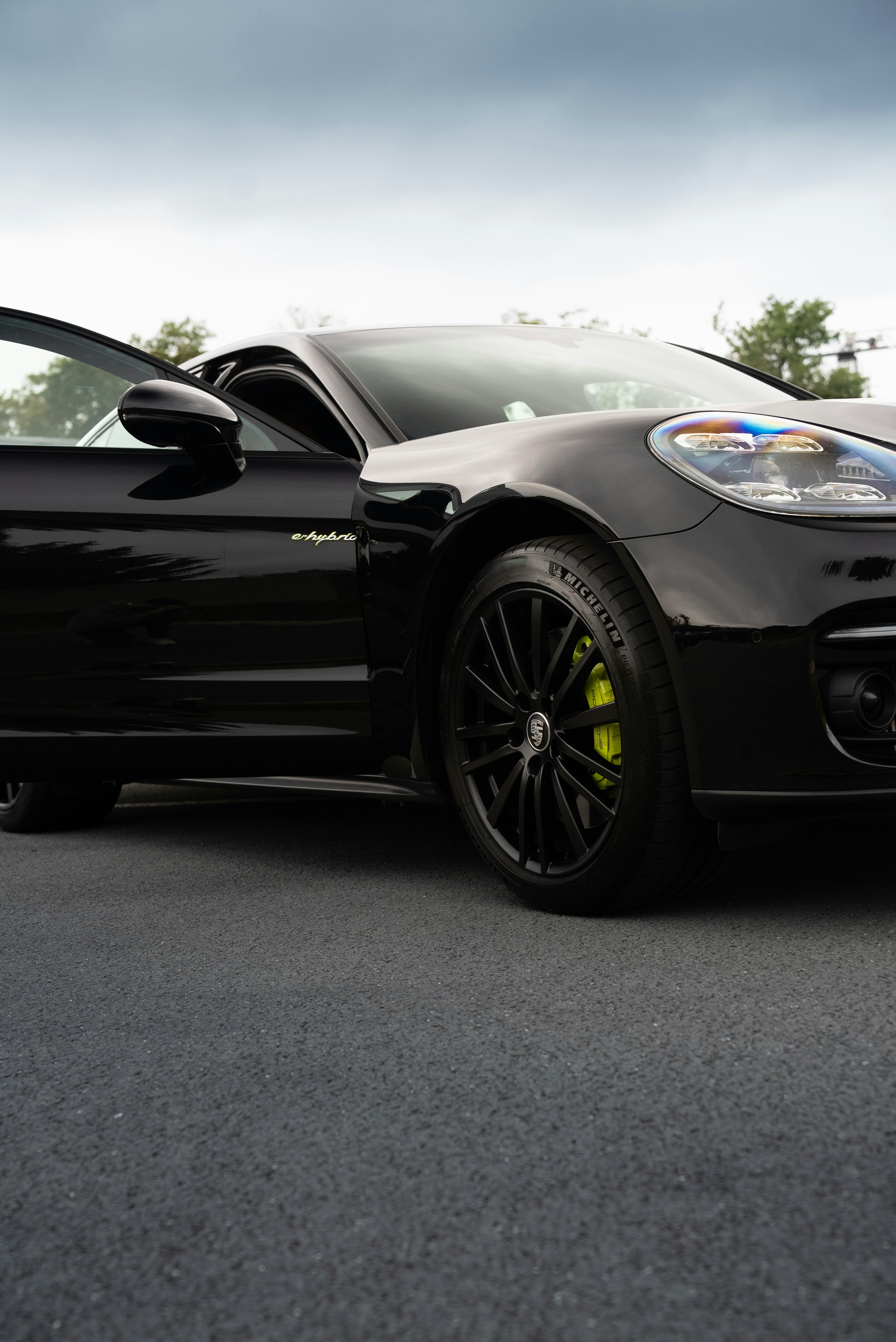 Porsche hitam ramping dengan pintu terbuka.