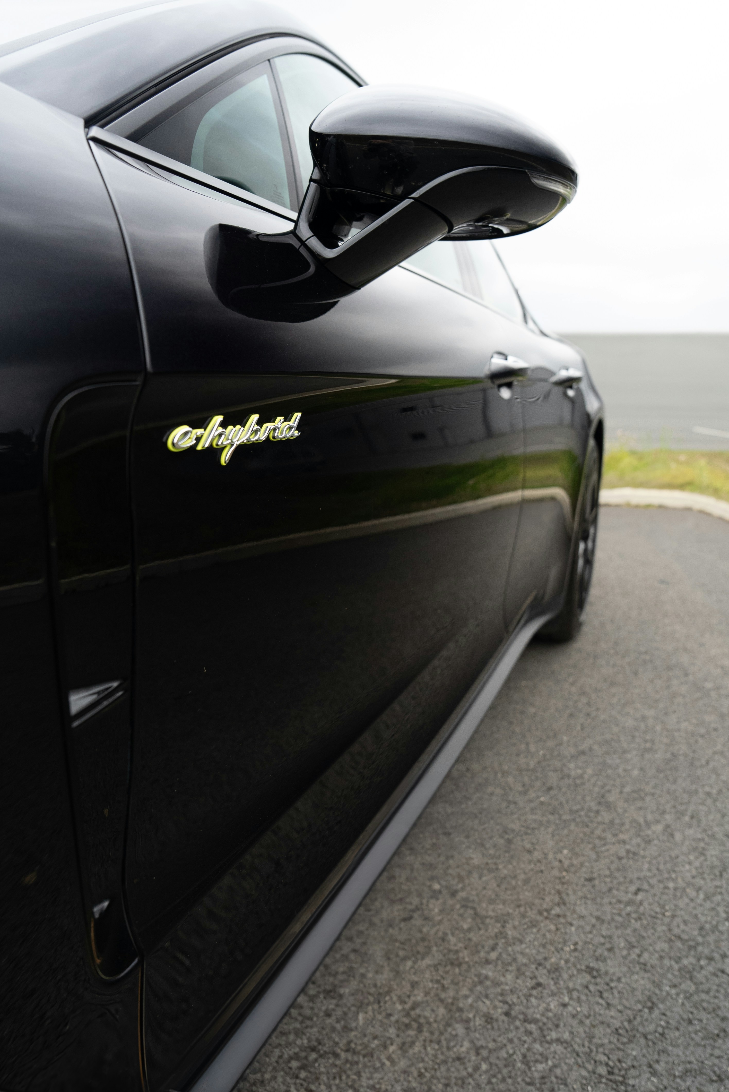 Black porsche e-hybrid car on asphalt.