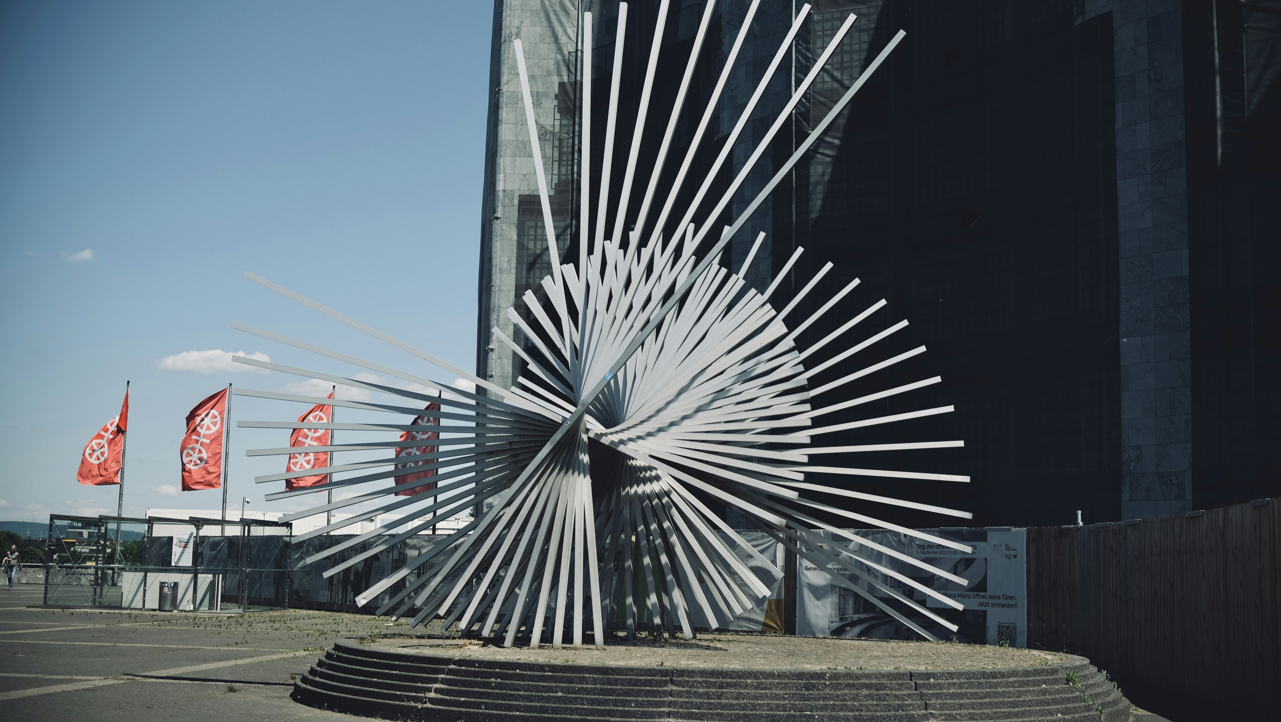 A modern sculpture stands outside of a building.