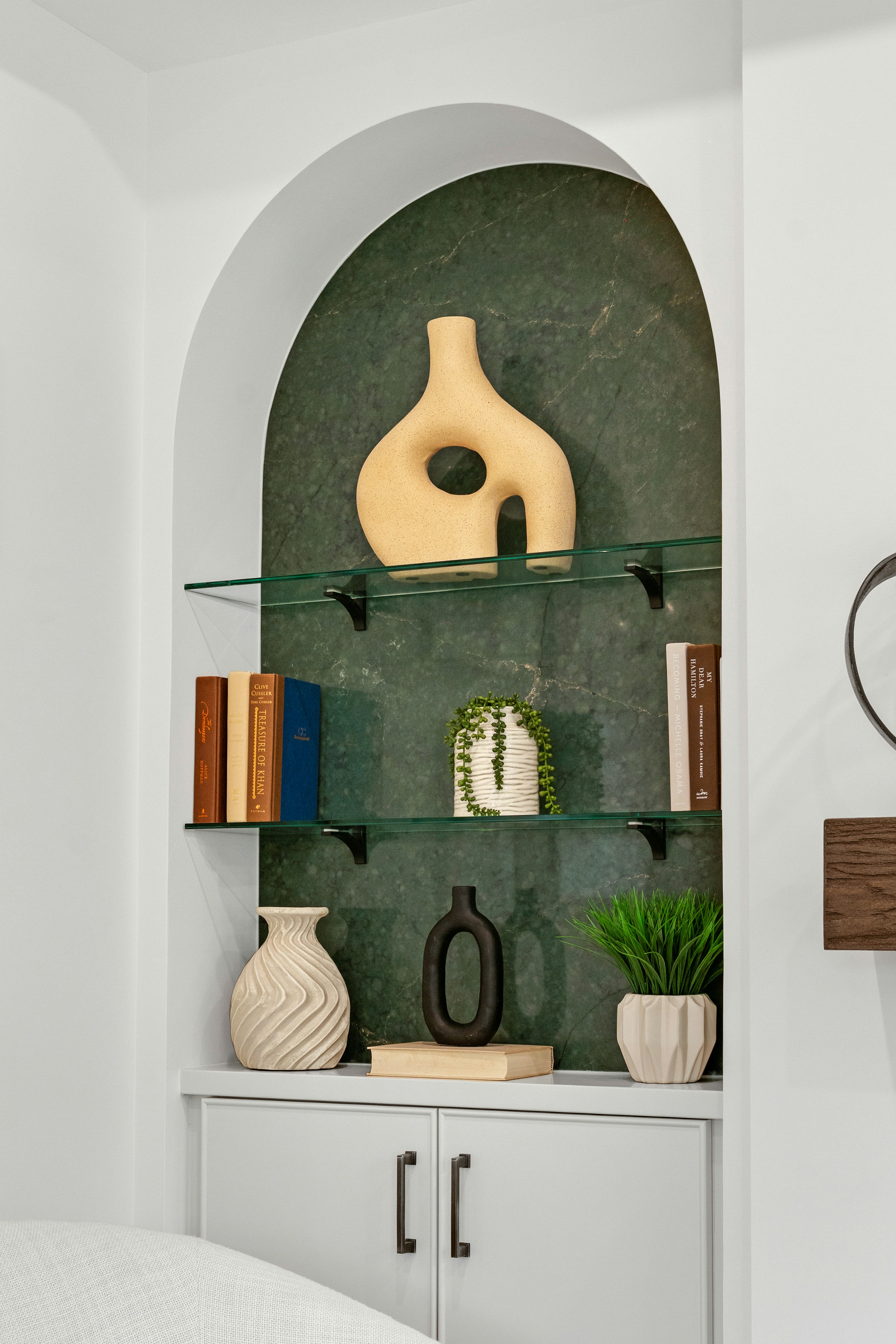 Une alcôve élégante exposant des objets décoratifs sur des étagères en verre.