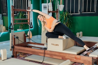Woman doing pilates on a piece of equipment.