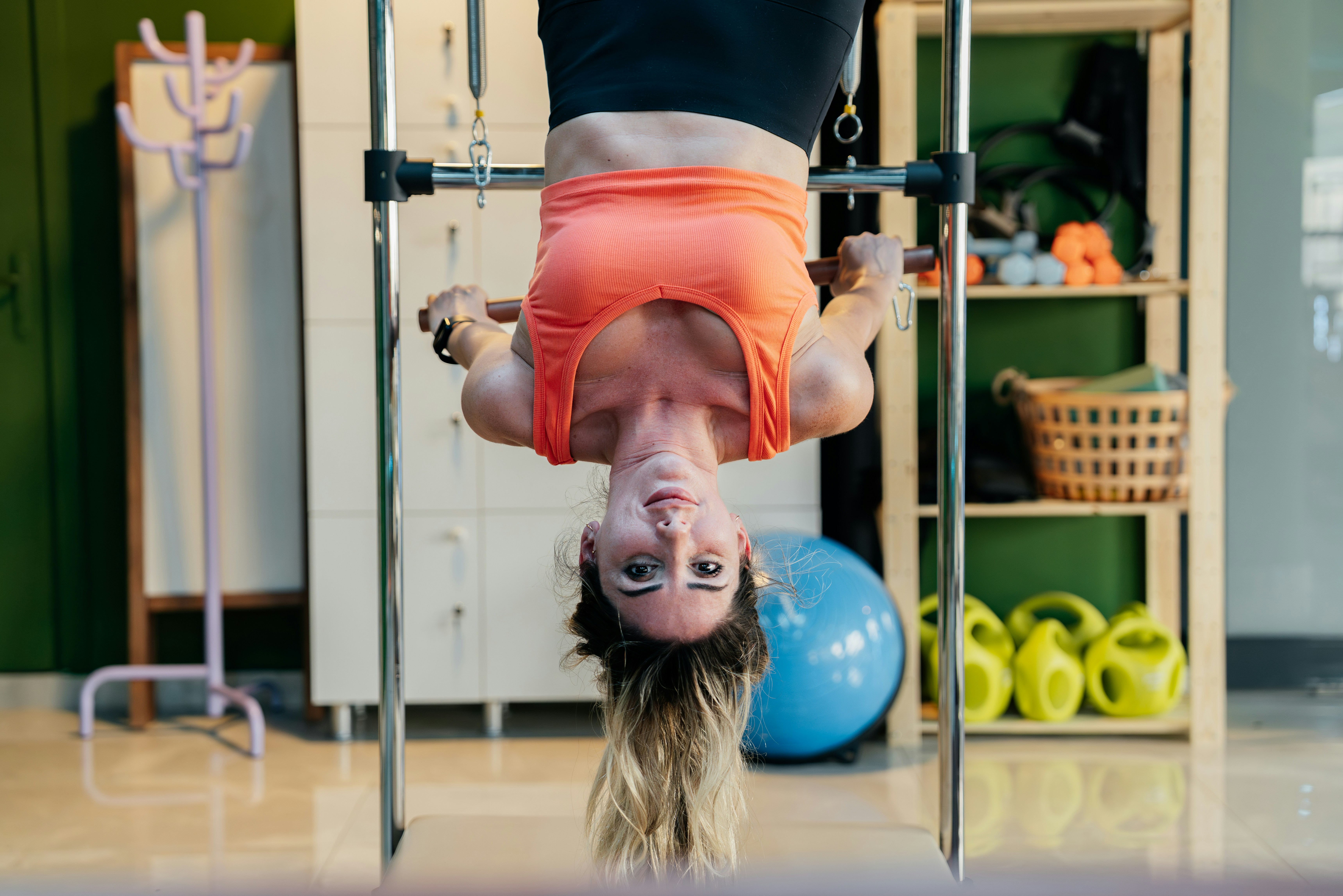 Woman hangs upside down in a gym.