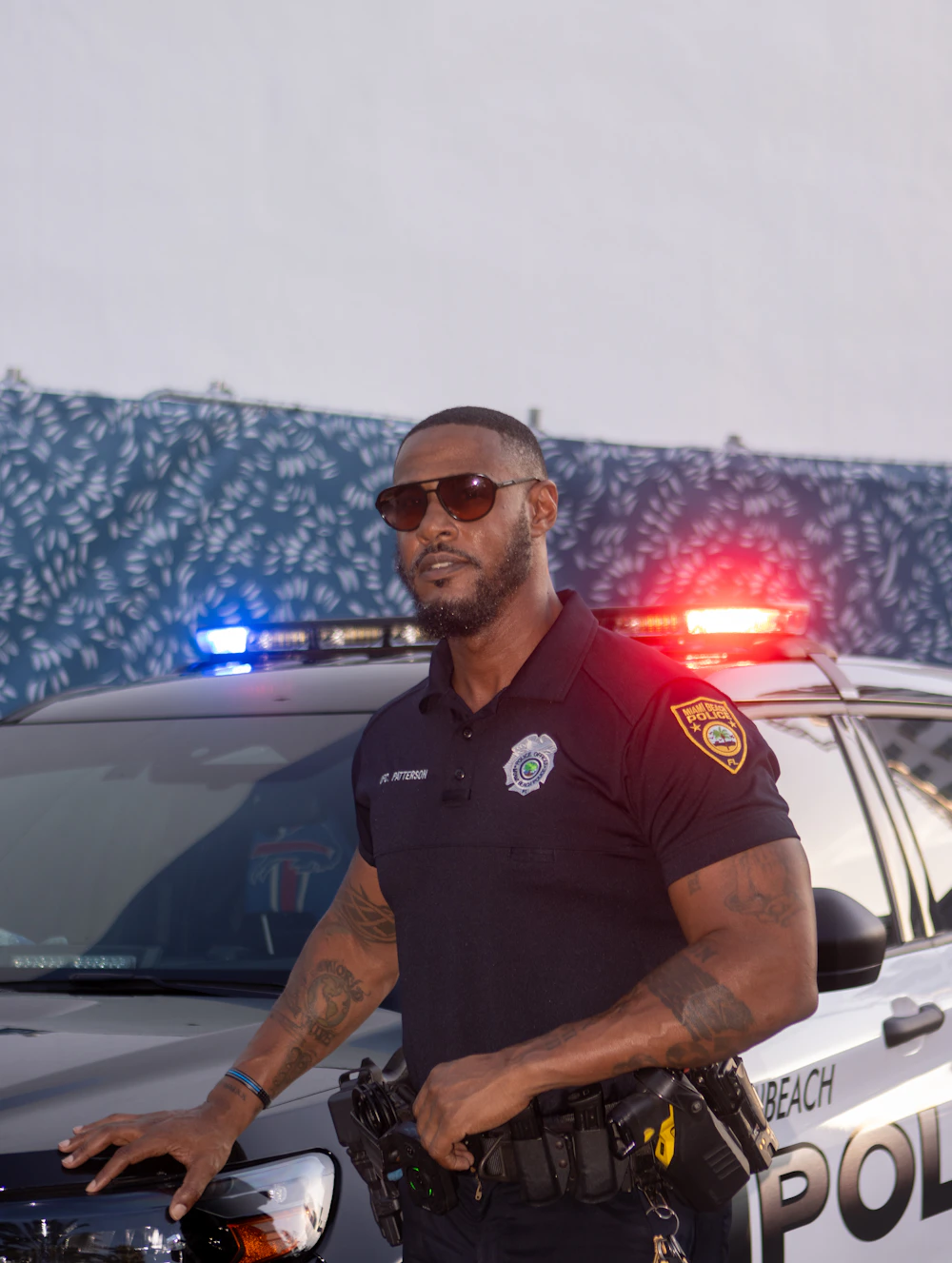 United States police officer standing beside a marked patrol vehicle
