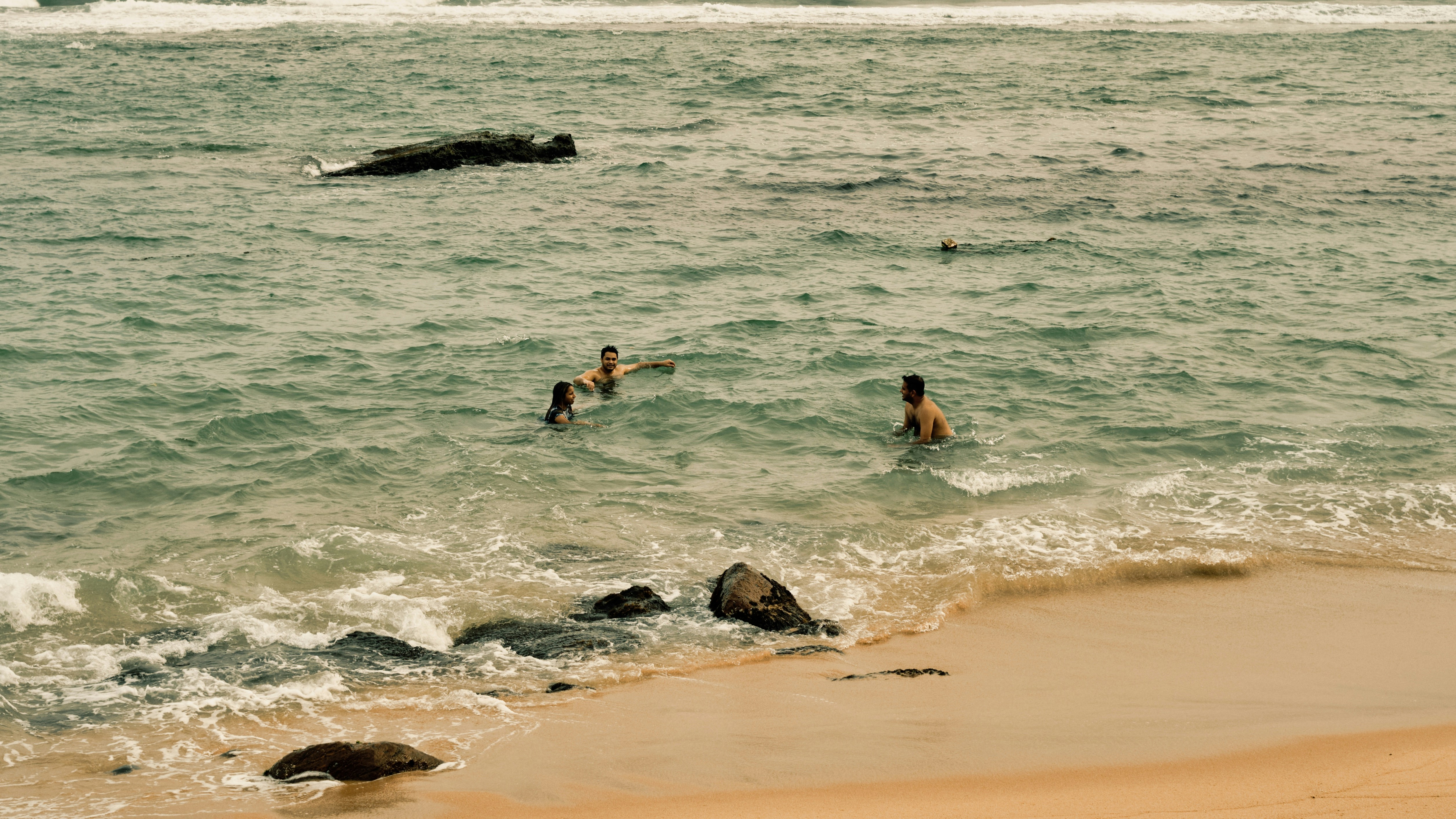 People are swimming in the ocean at the beach
