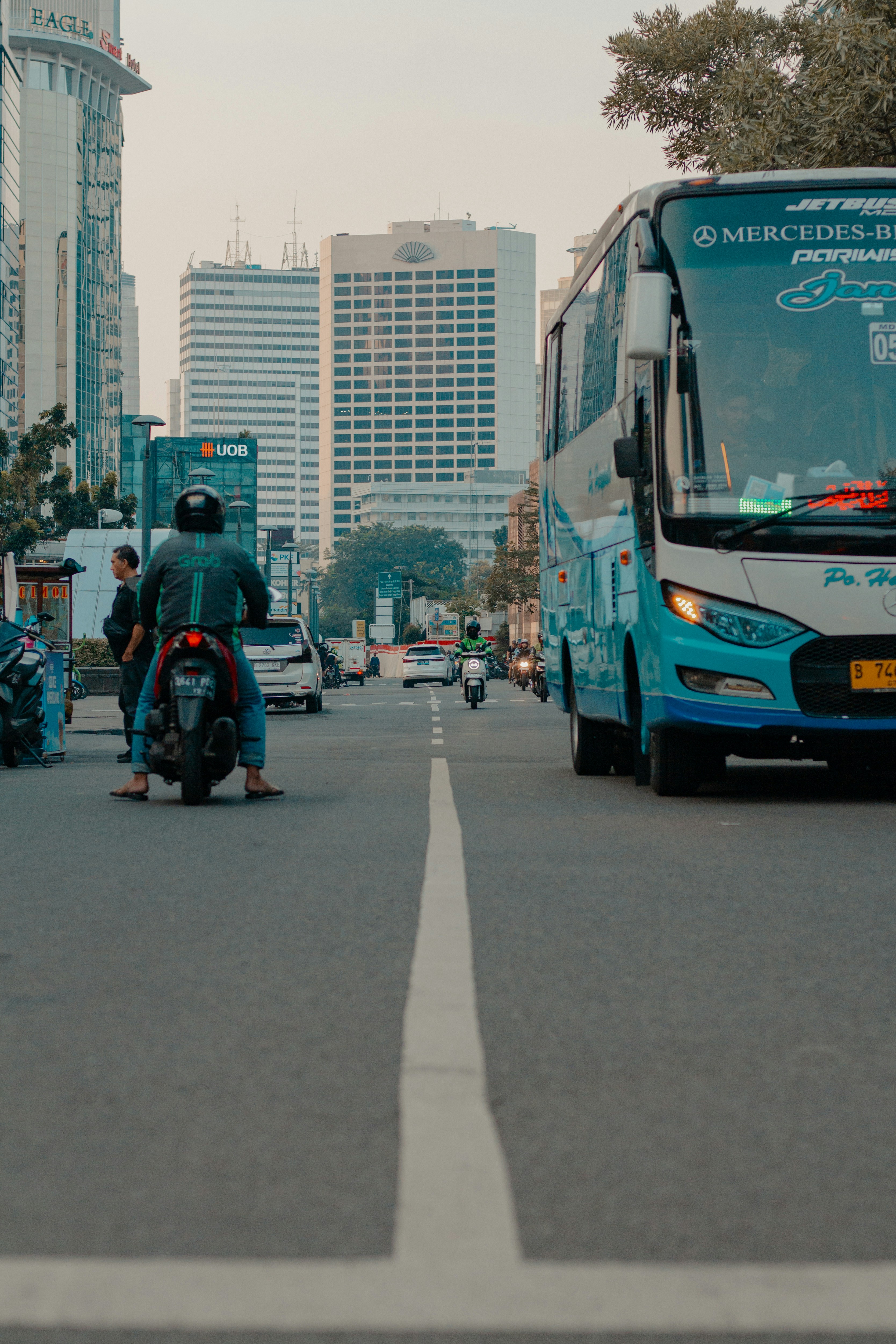 Traffic flows through a city street with vehicles.