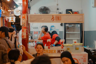 People are working at a busy food stall