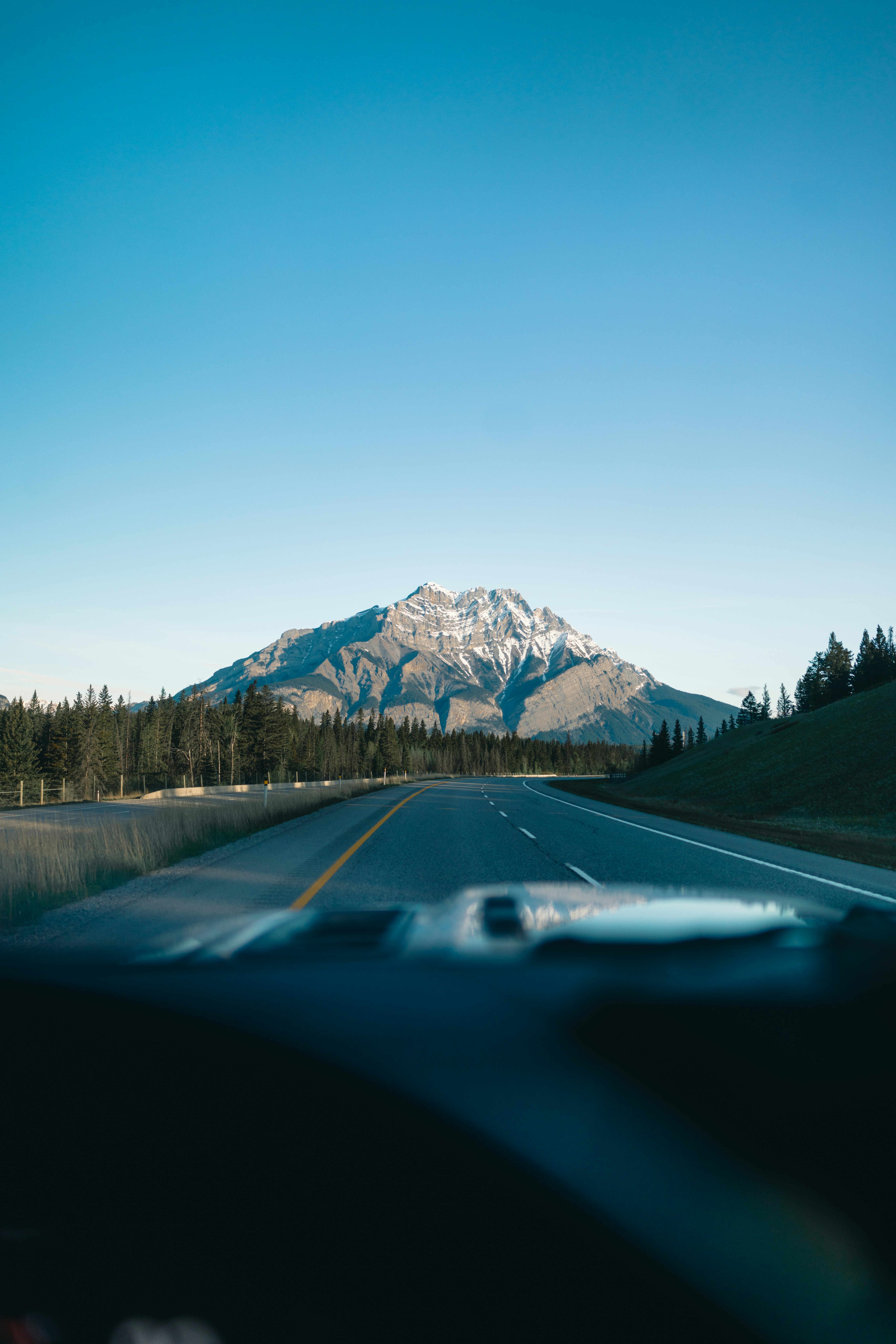 Road towards a mountain under a clear sky.