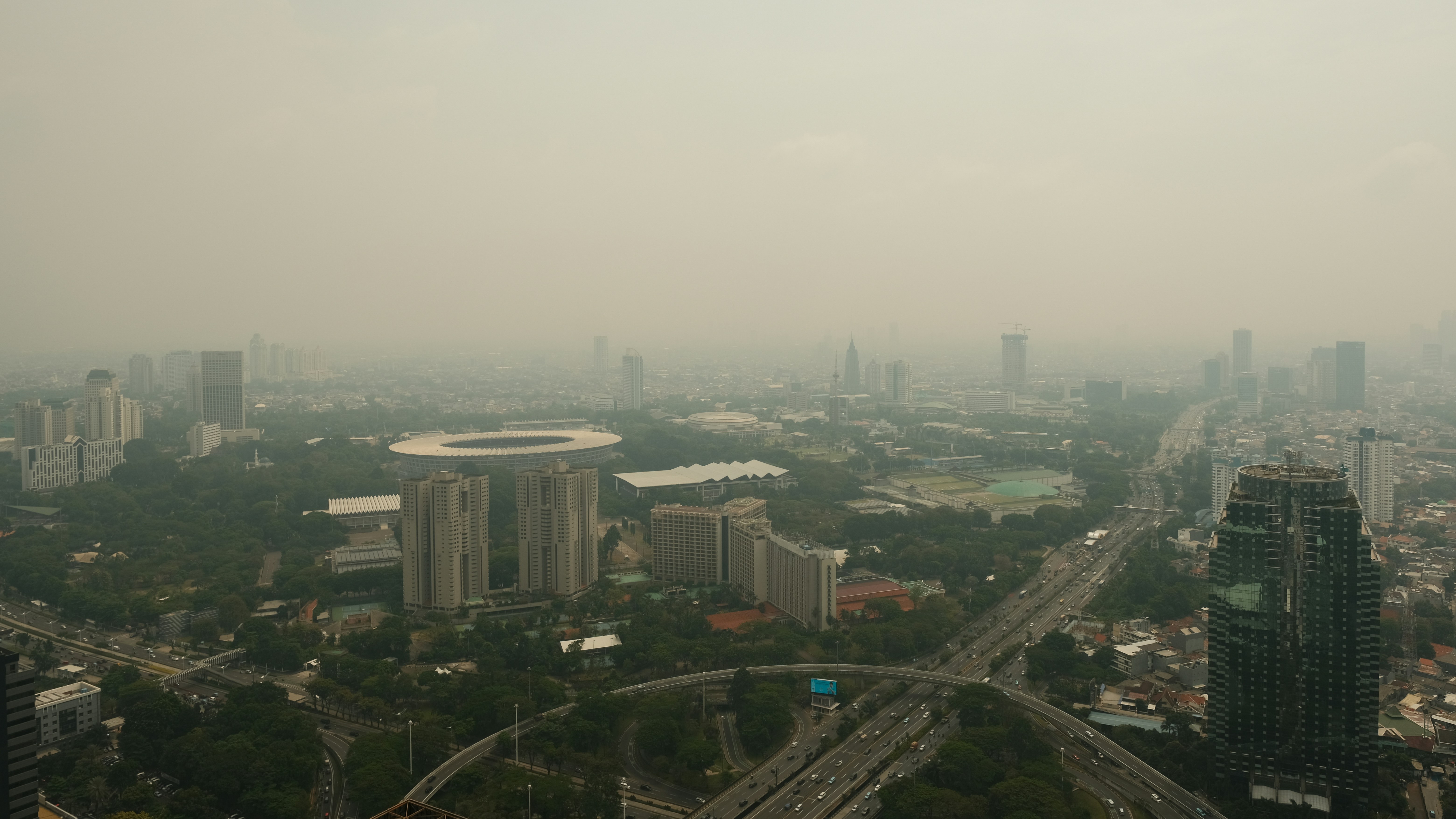 Smog blankets a hazy city skyline.