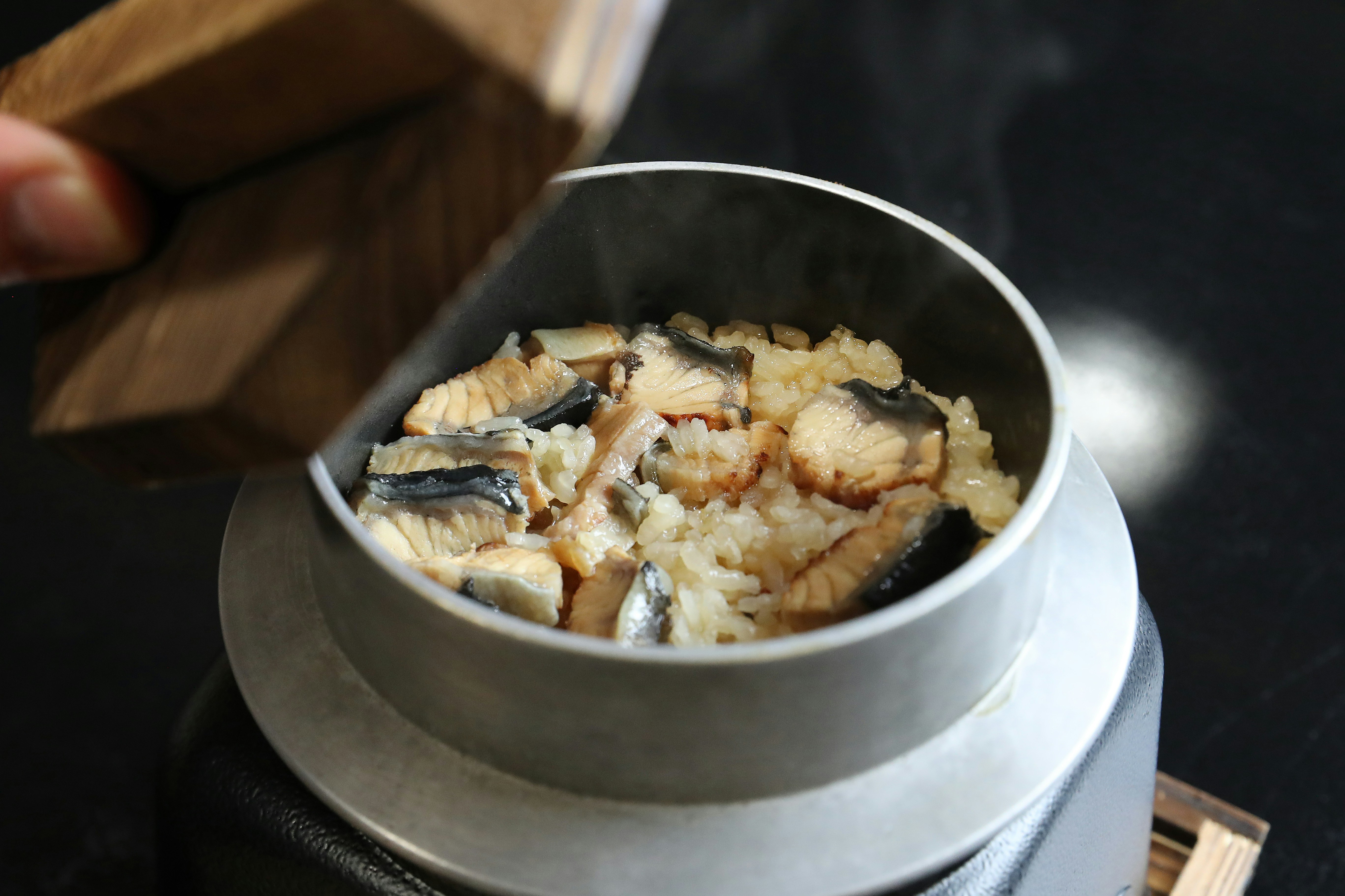 A steaming pot of cooked rice and fish.
