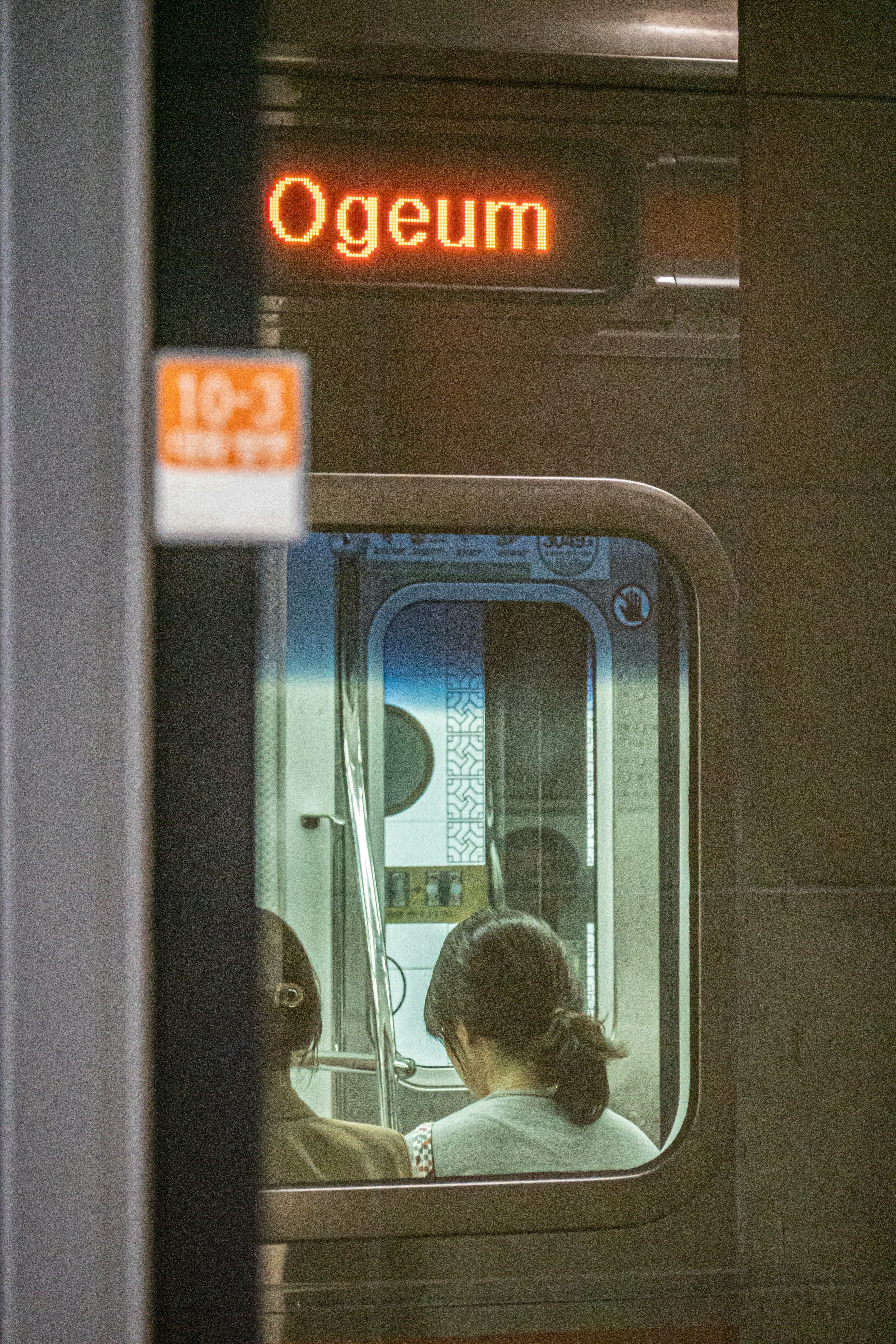 People sit inside a train car in ogeum station.