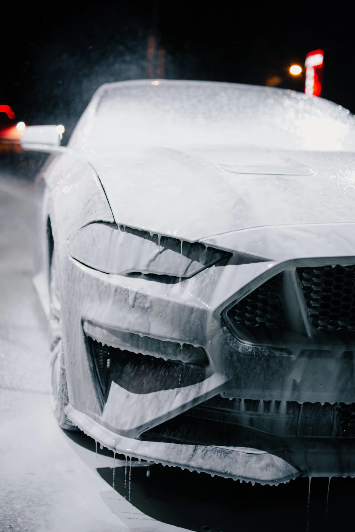 A car being washed with foam and suds