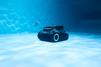 A robot vacuum is cleaning a pool underwater.