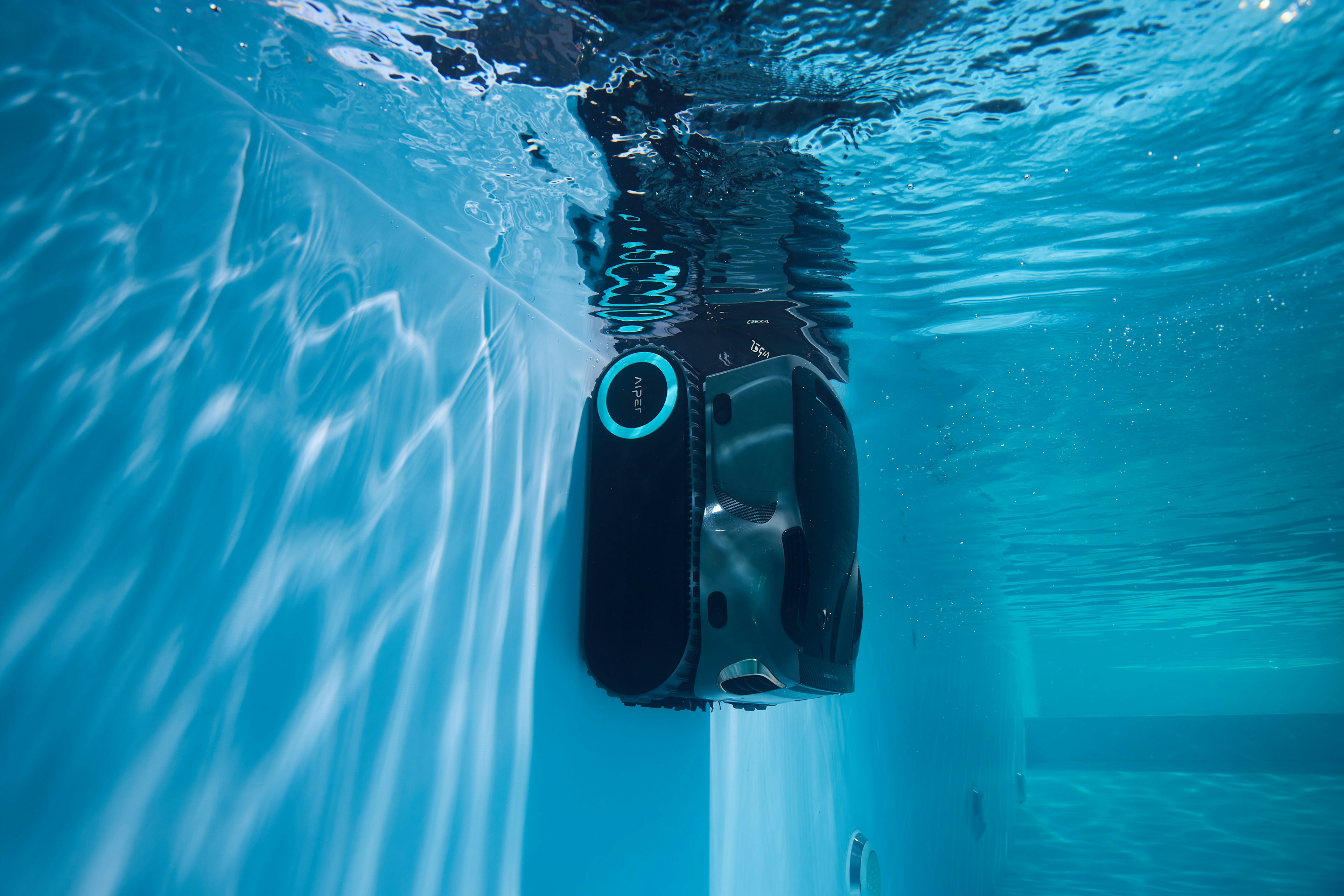 An autonomous submersible robot with glowing optical sensors and manipulator arms, inspecting the submerged base of a hydroelectric dam in clear water.
